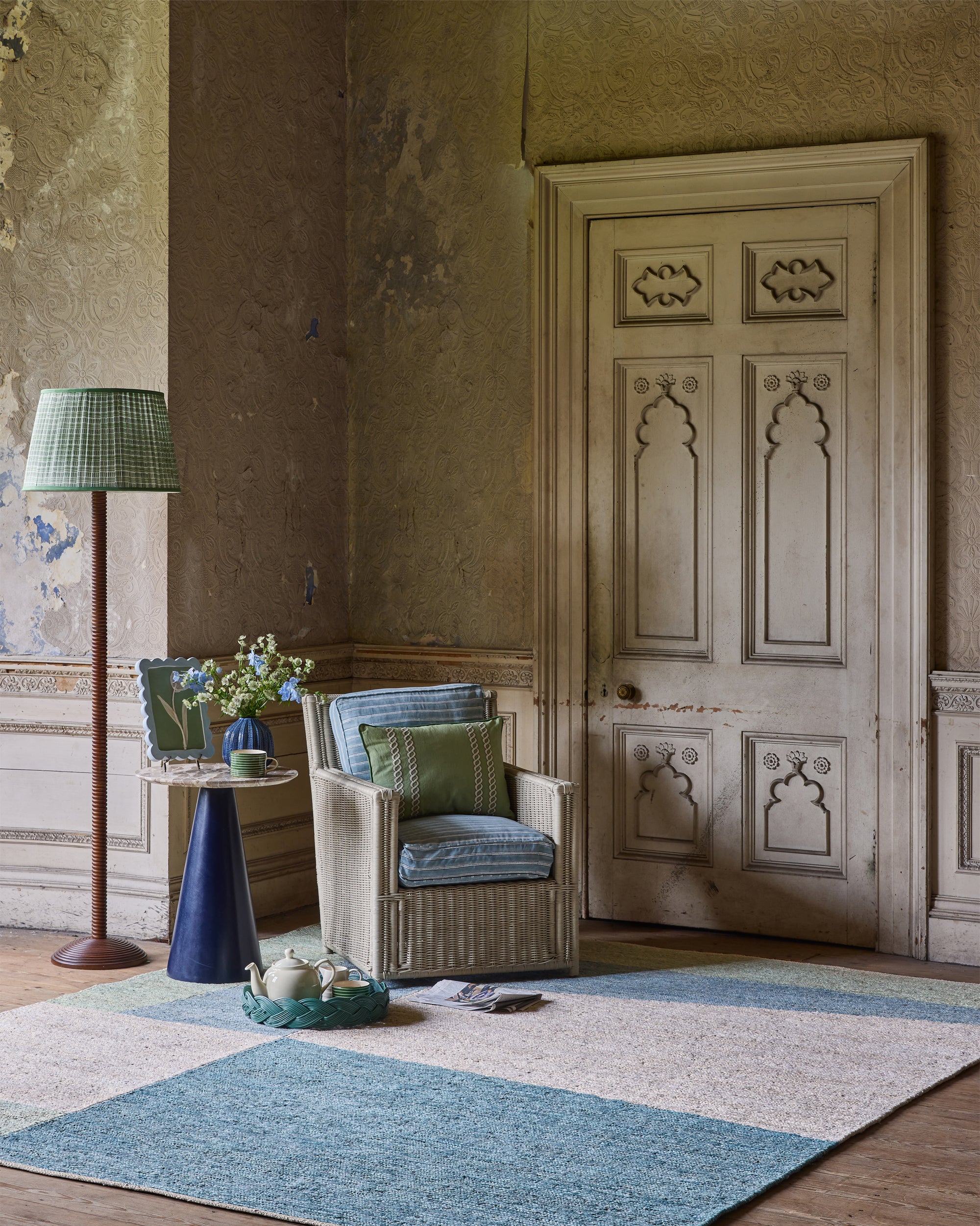 Living room with a chair, lamp, and decorative items on a patterned rug.