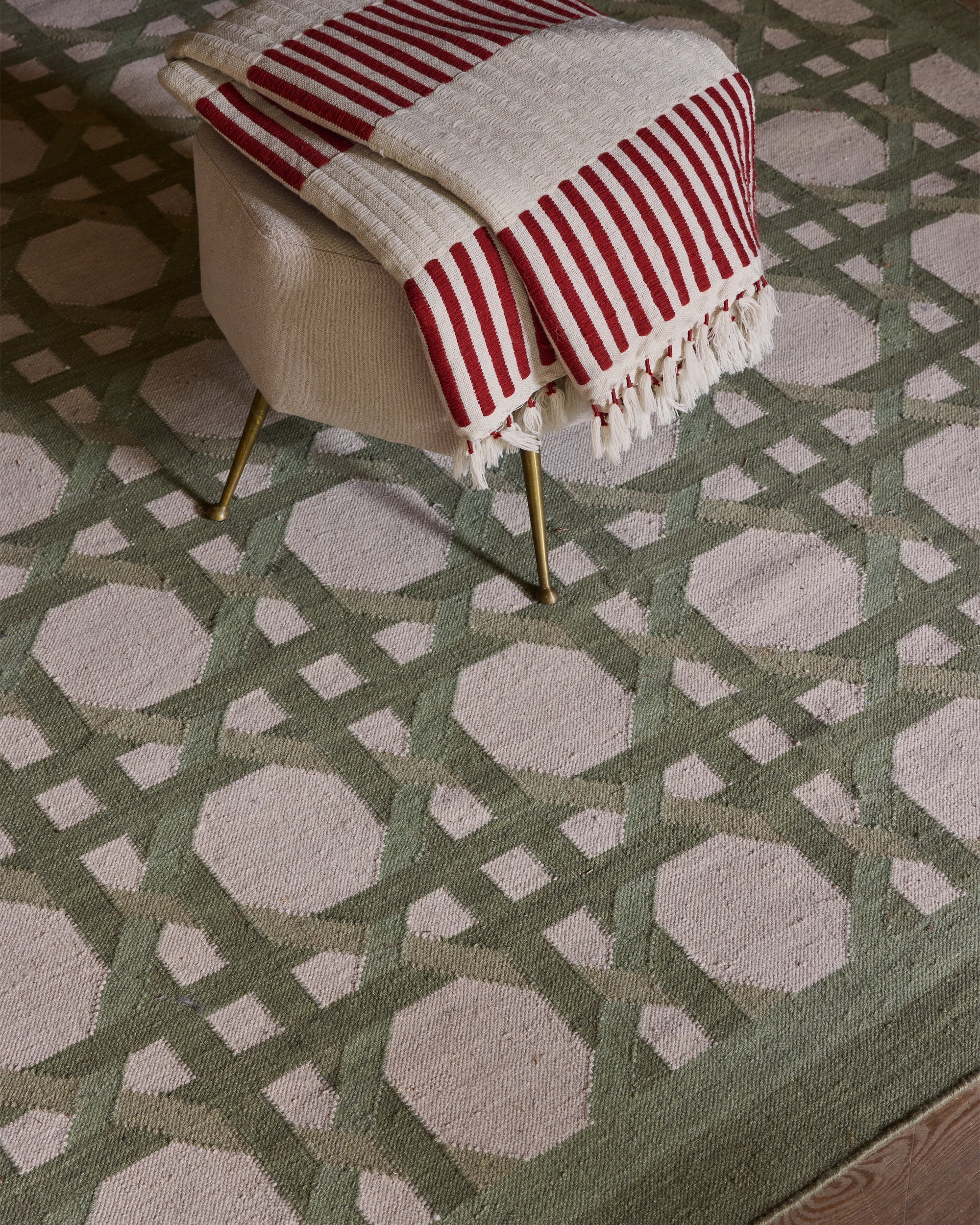 Patterned rug with a chair and striped blanket on a geometric design
