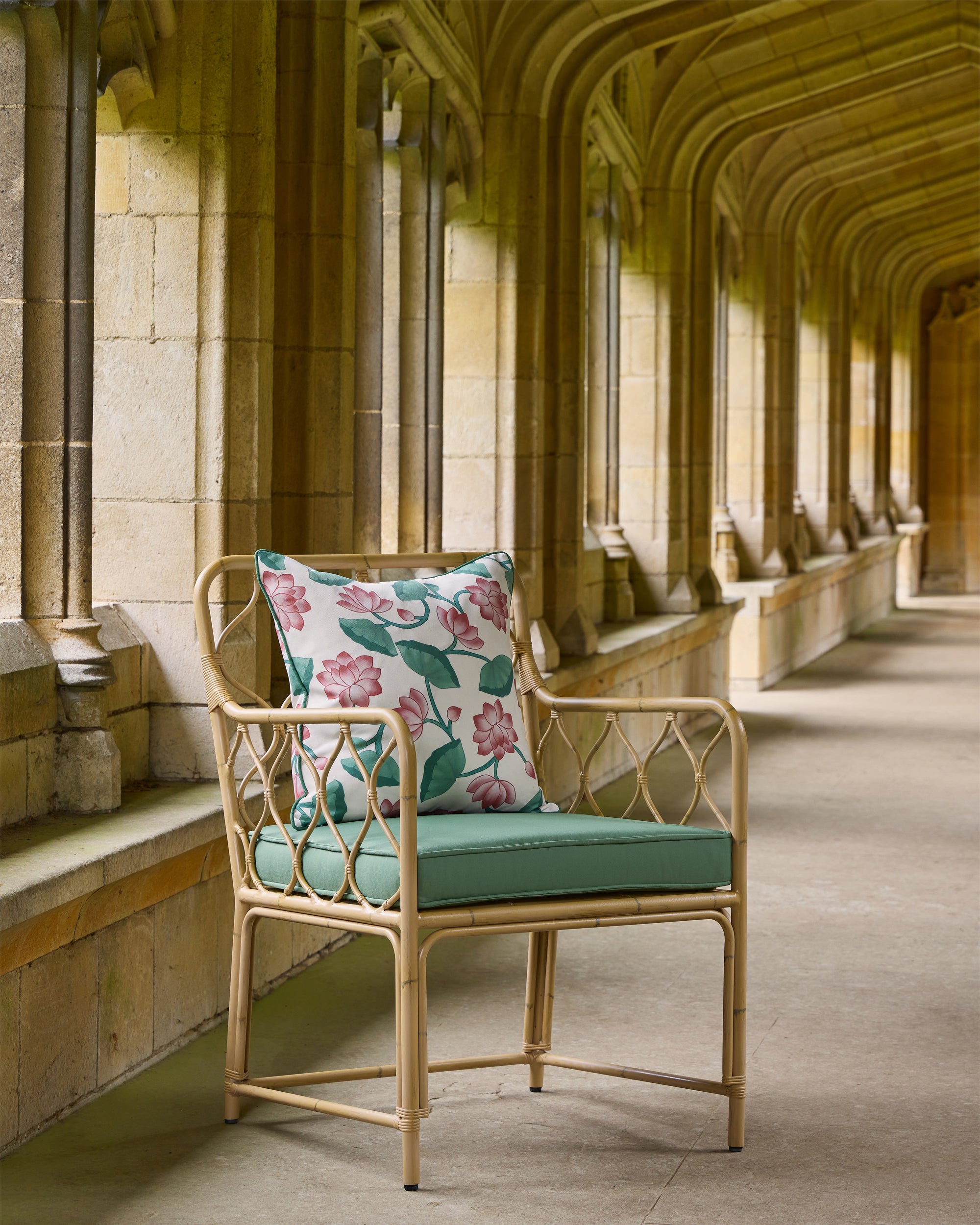 Aluminium chair with floral pillow in a stone corridor