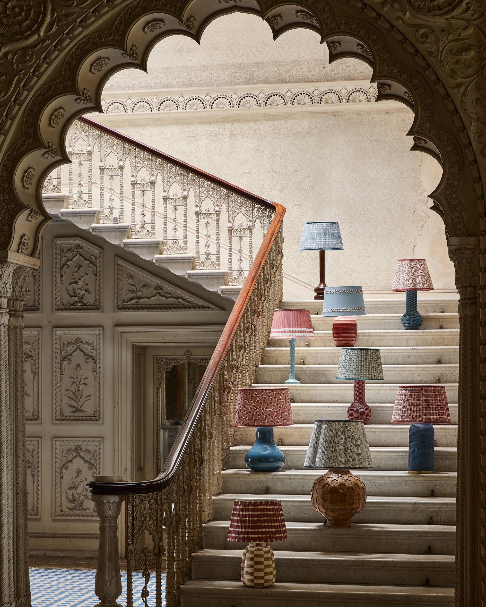 Decorative lamps on a staircase with ornate wall and archway
