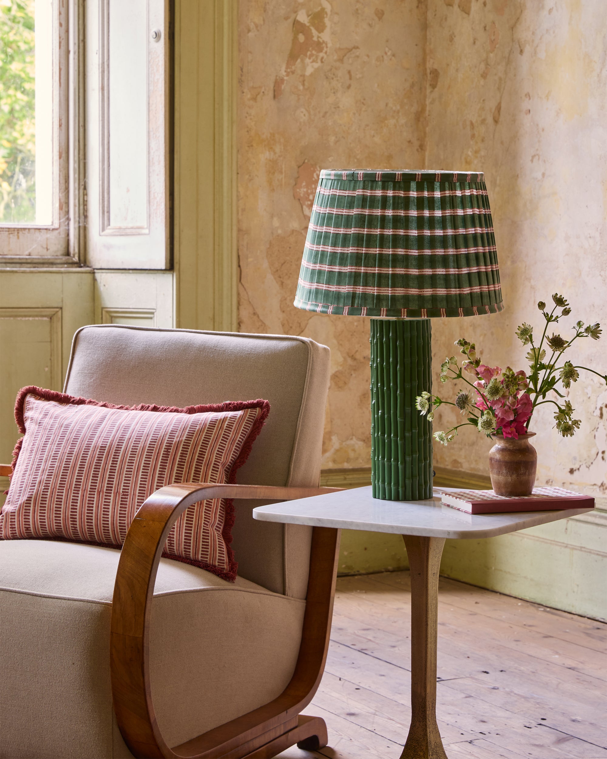 Living room with a beige armchair, small table, and decorative lamp.