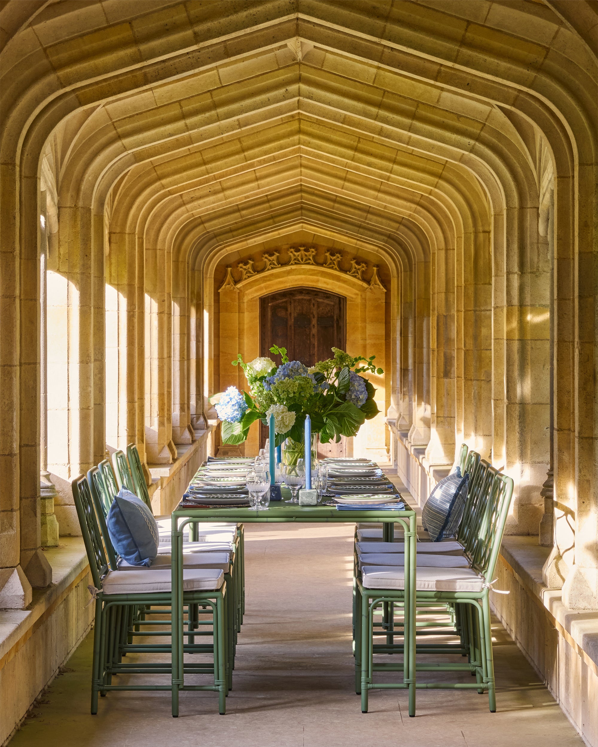 Dining area with a long table and chairs in a stone hallway