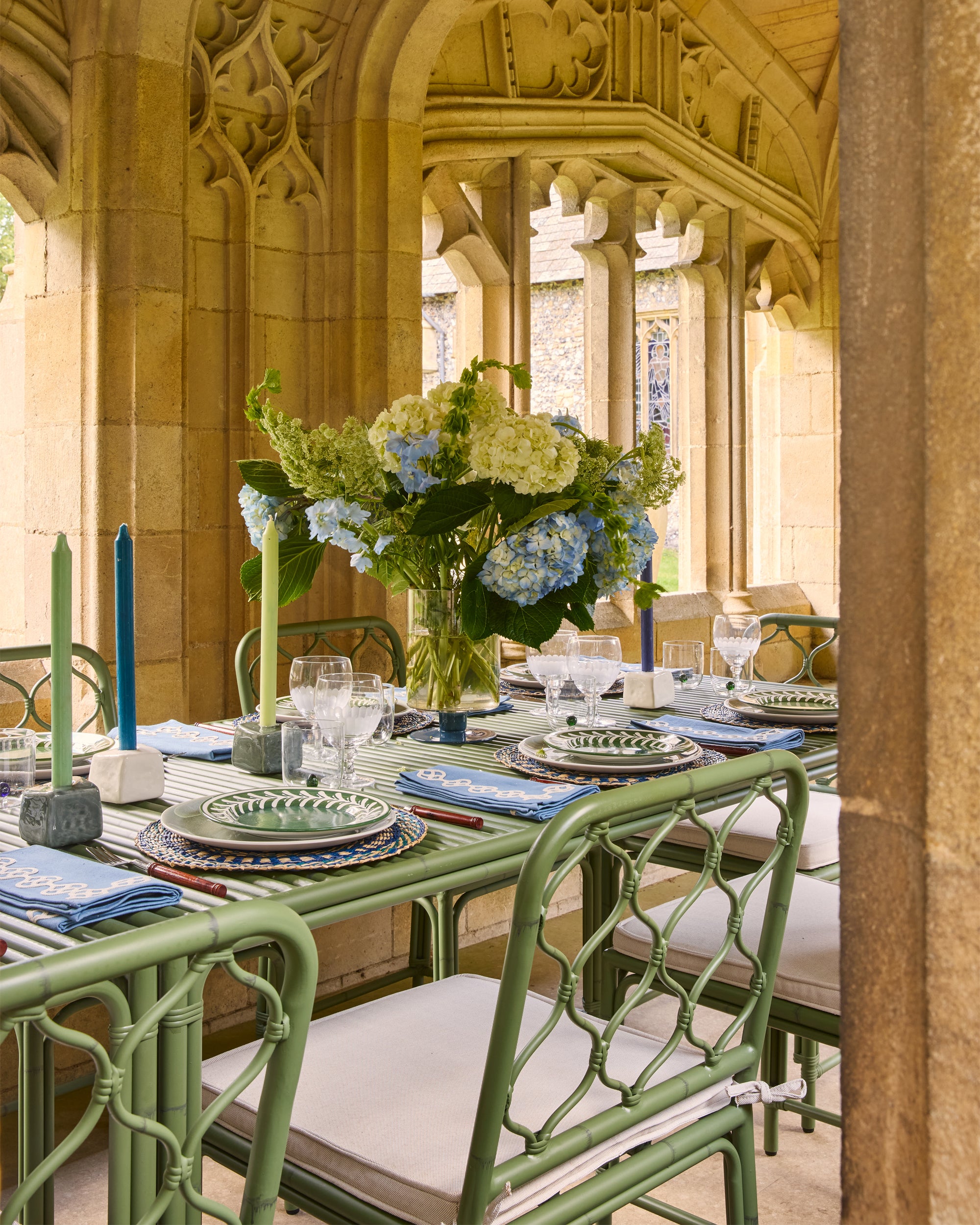 Elegant dining table setting with flowers and candles in a historic building.