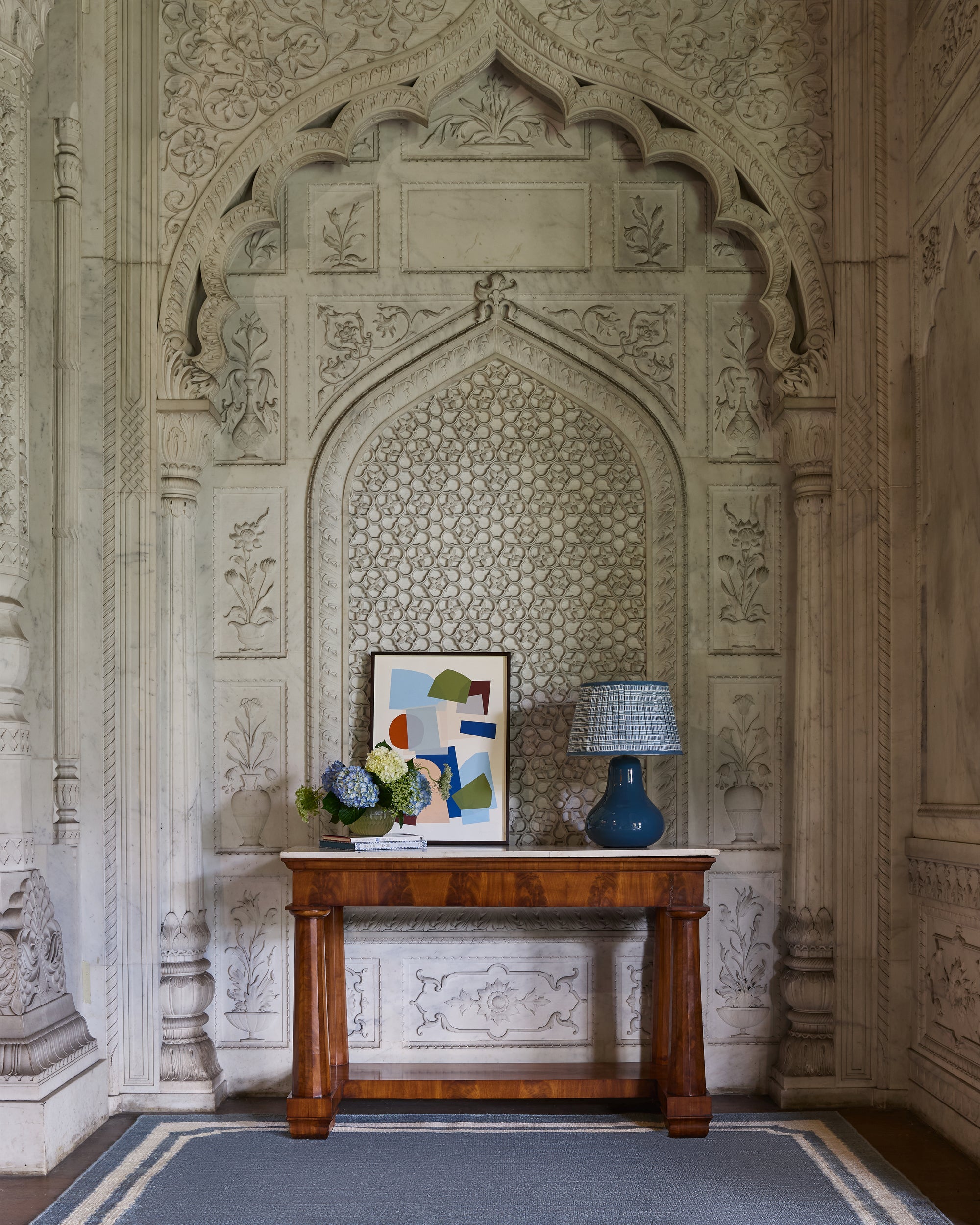 Decorative interior with a wooden table against an ornate wall.