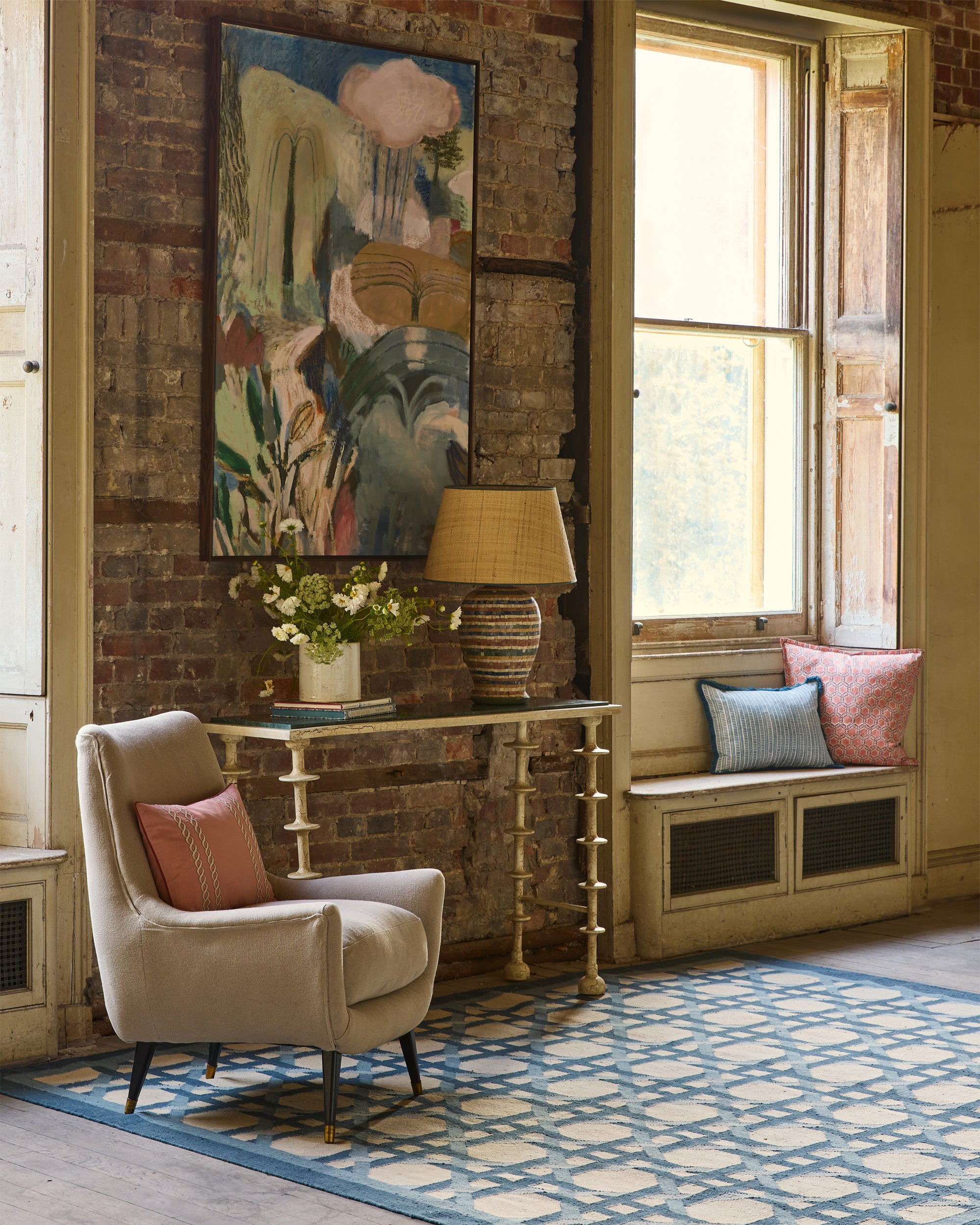 Living room with a brick wall, armchair, and decorative elements.