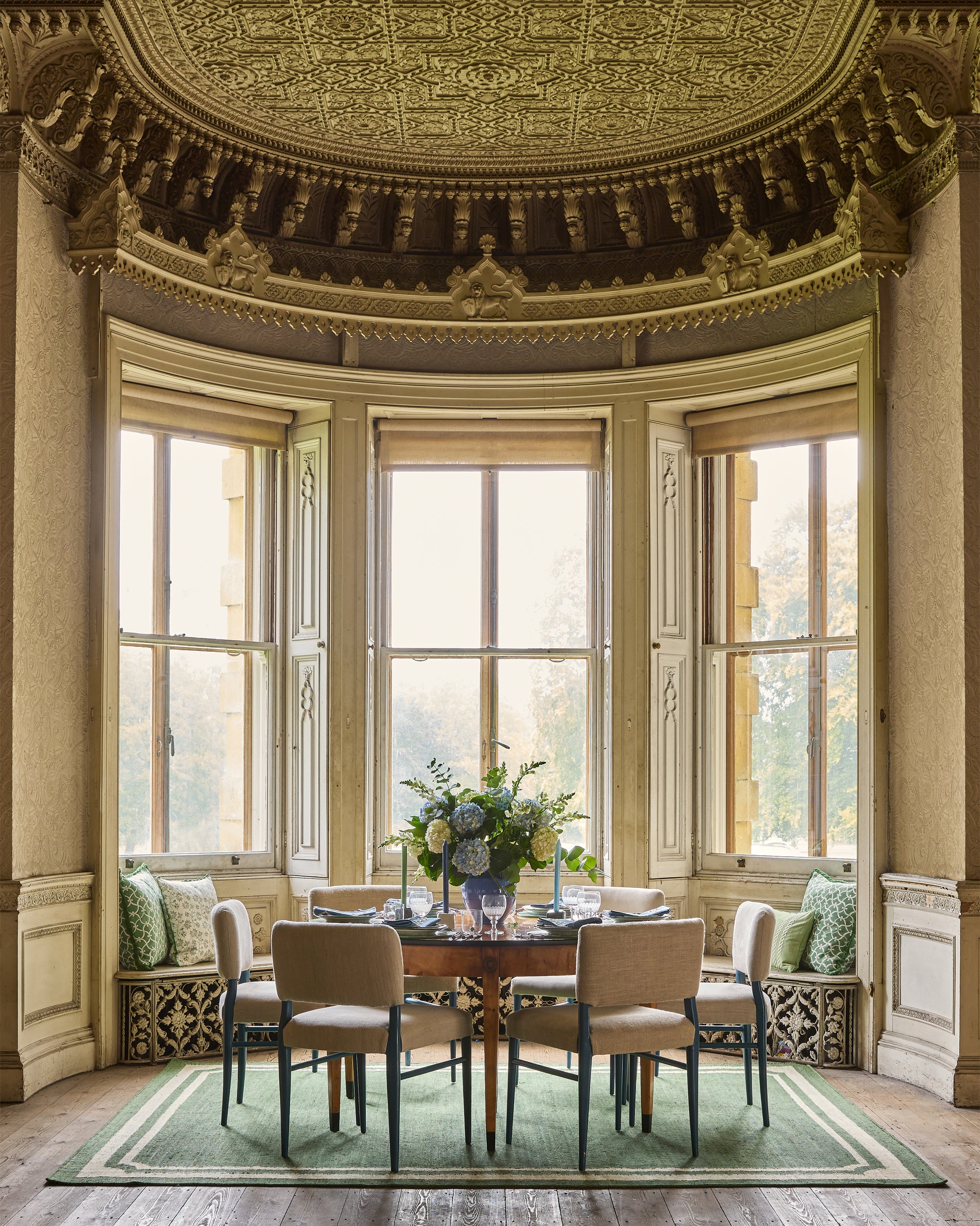 Elegant dining room with ornate ceiling and large windows