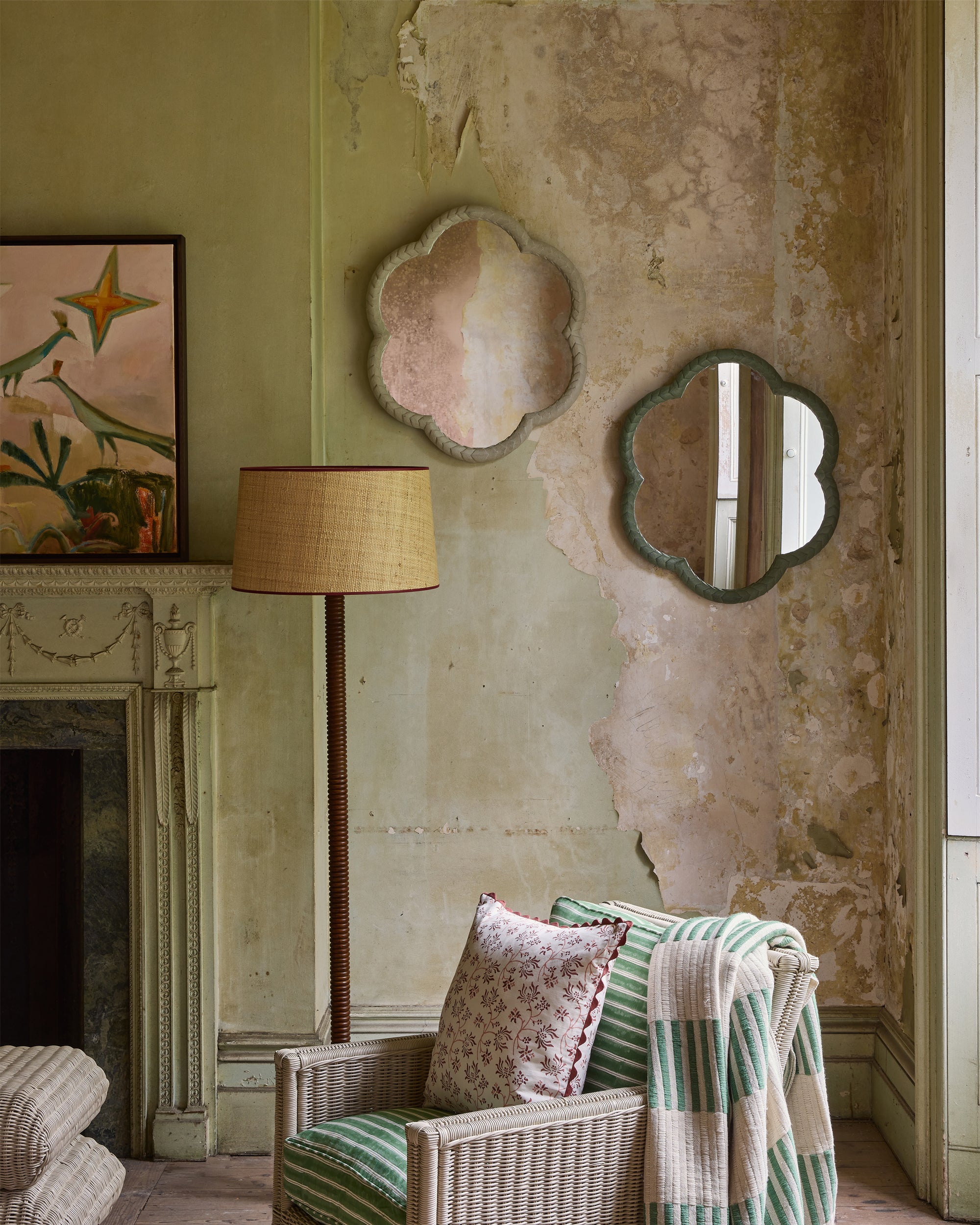 Living room with wicker chair, lamp, and decorative mirrors on a textured wall.