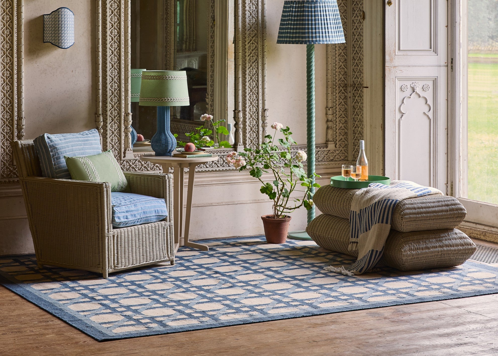 Living room with wicker effect armchair, ottoman, and decorative items on a patterned rug.