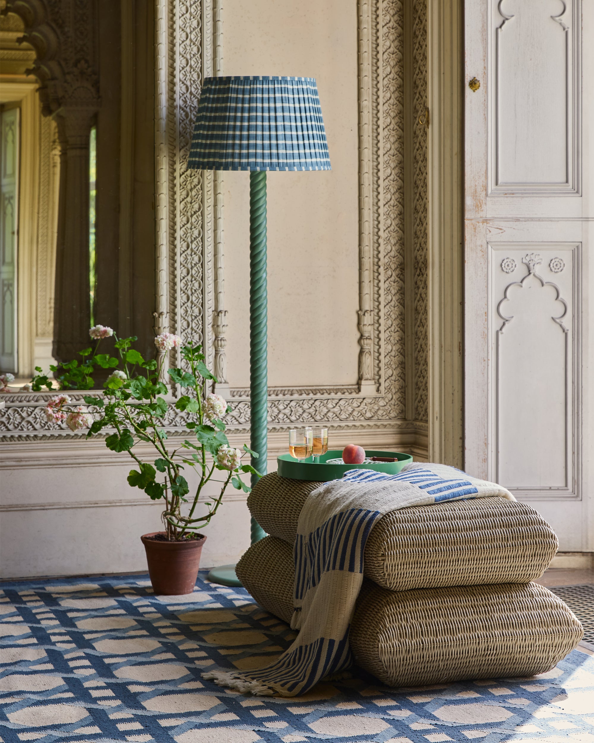 Decorative room with patterned rug, pillows, and lamp.