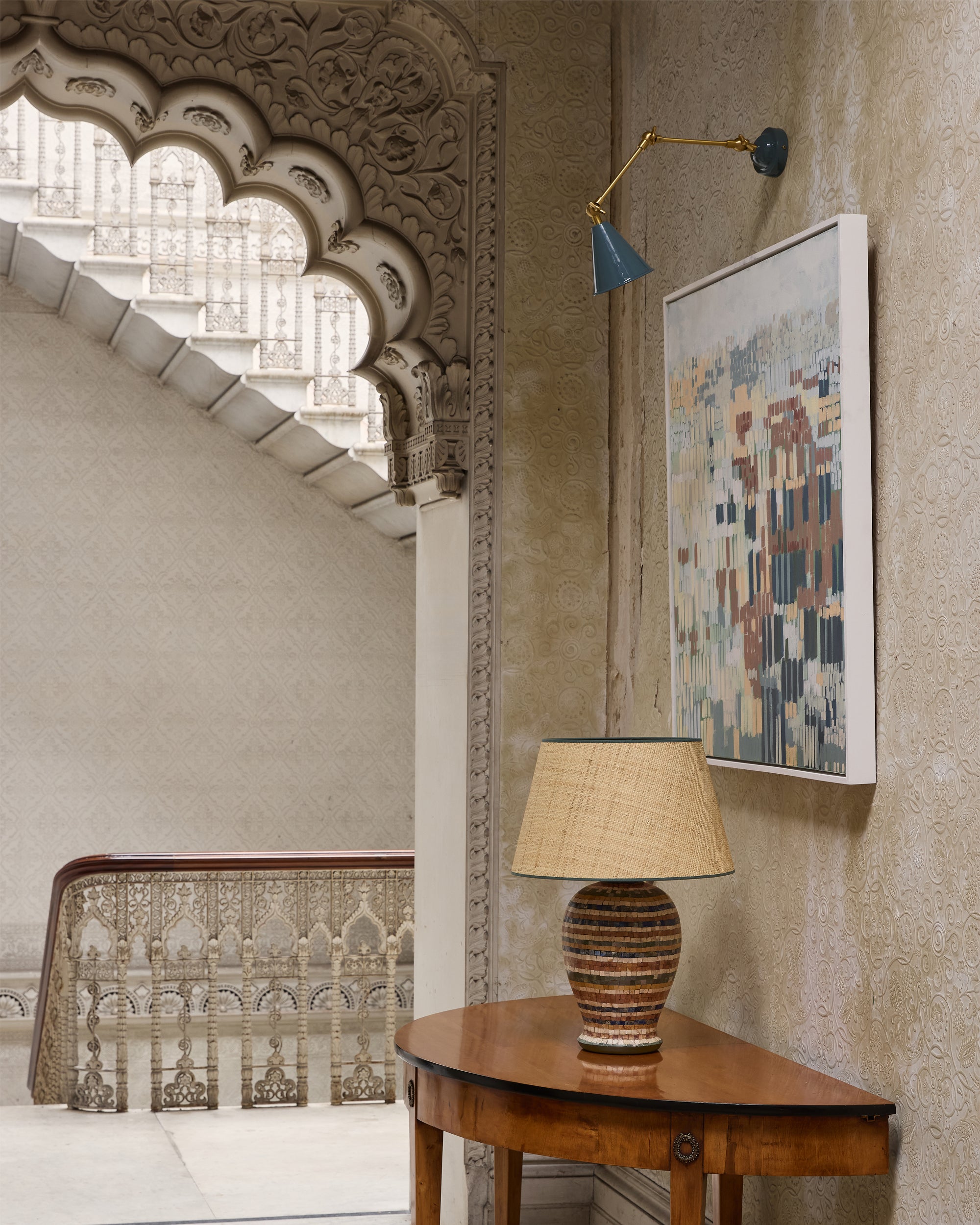Decorative interior with a table lamp, wall art, and architectural details.
