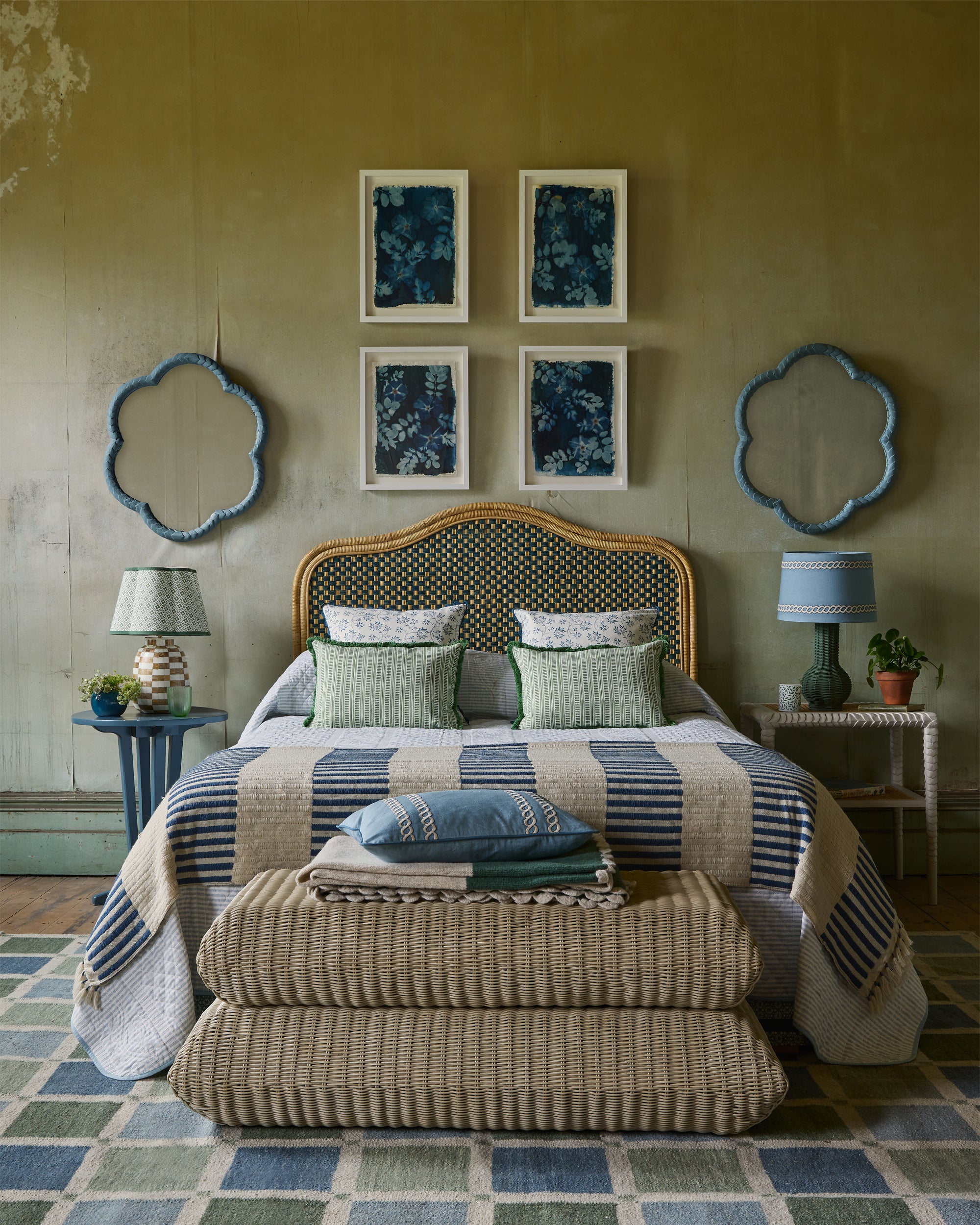 Bedroom with a bed featuring striped bedding and decorative pillows, flanked by two lamps on either side.