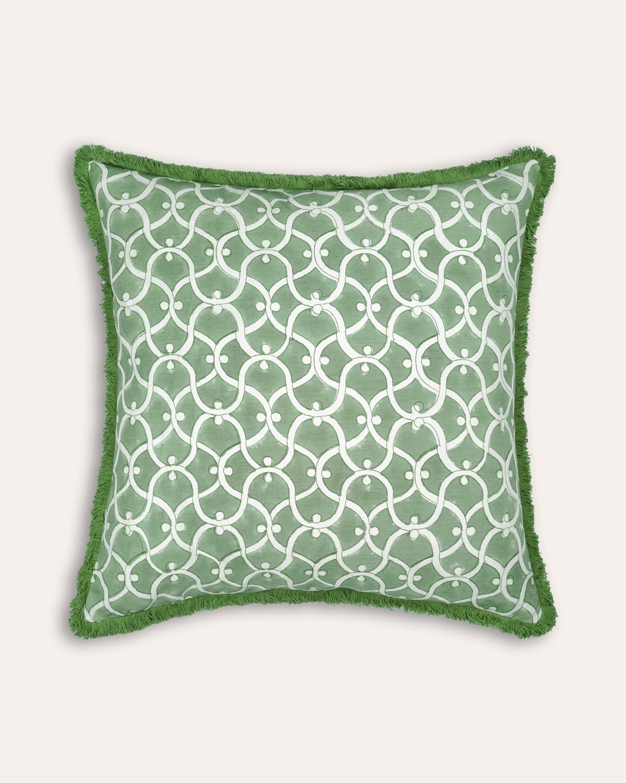 Green block printed square cushion with white geometric pattern on a white background