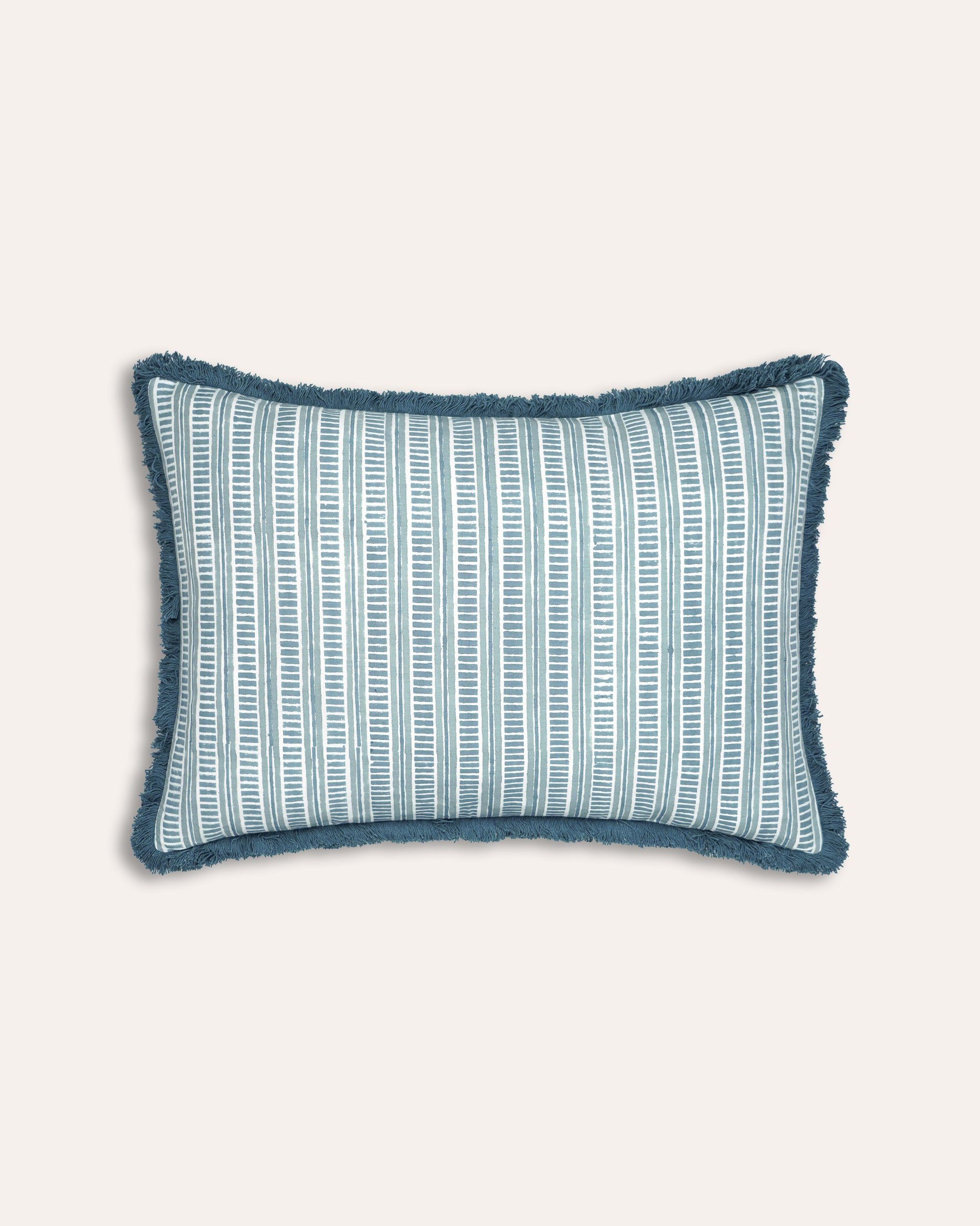 Blue patterned pillow with frayed edges on a white background