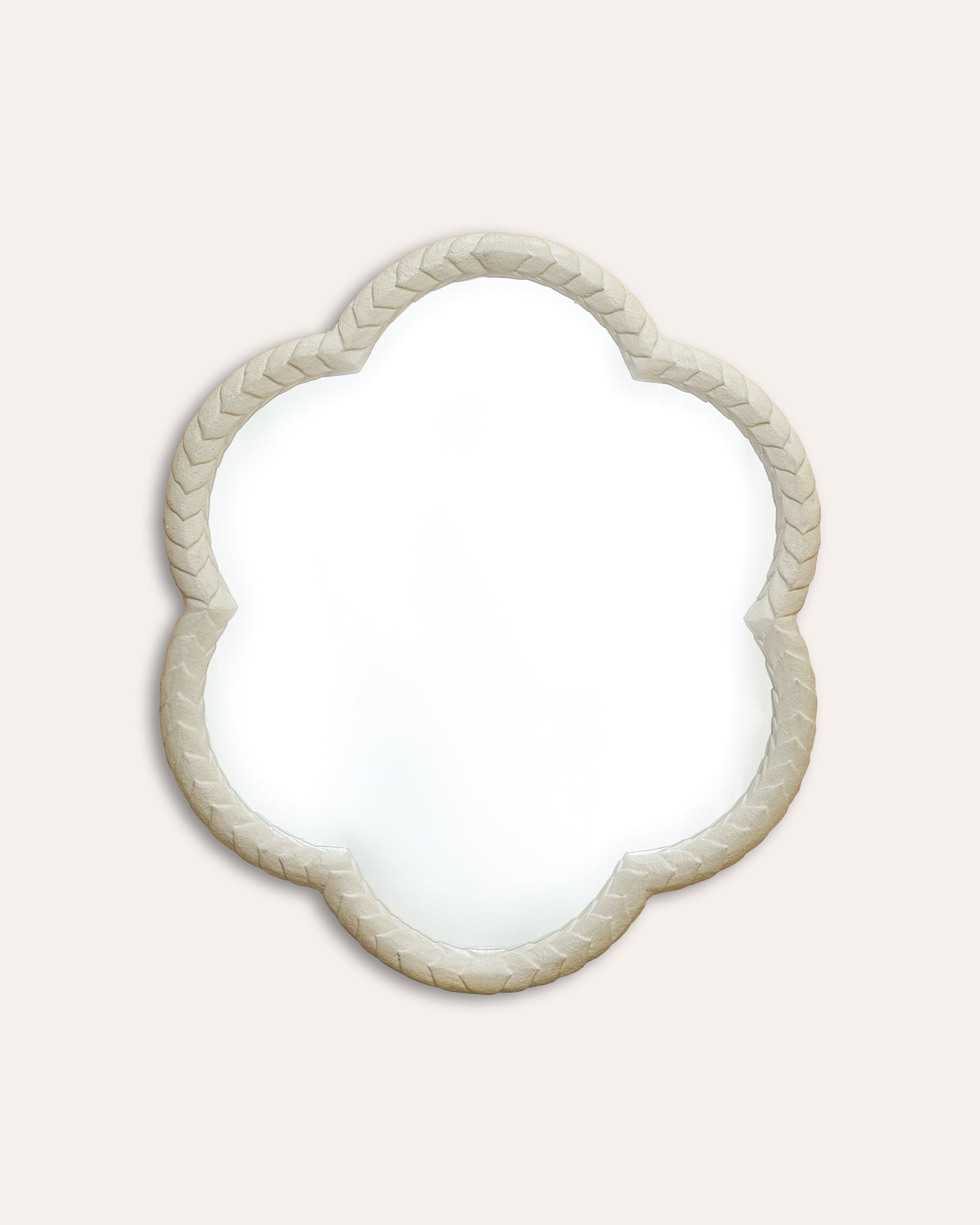 Decorative mirror with a braided frame on a light beige background