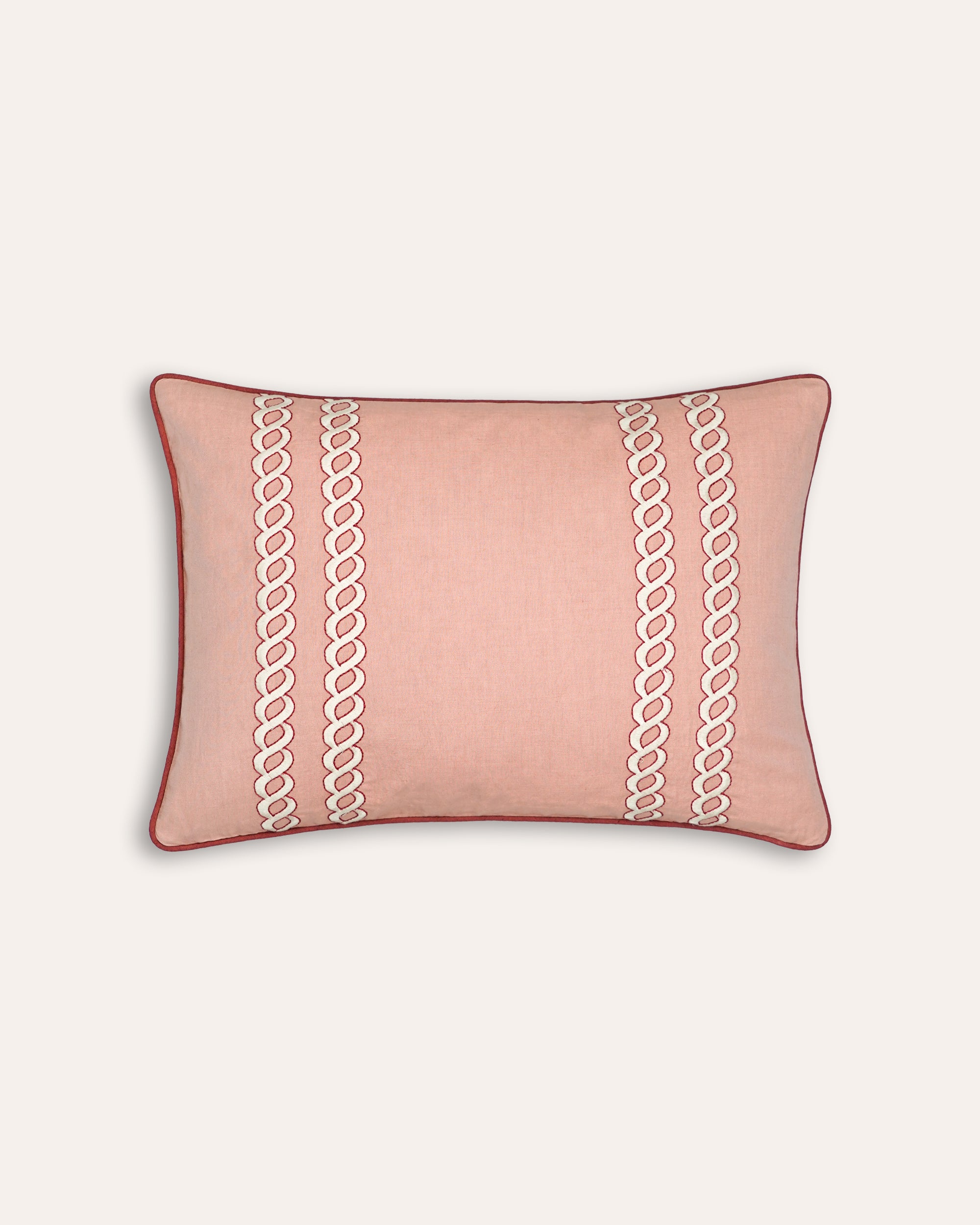 Pink rectangular cushion with white chain pattern on a beige background