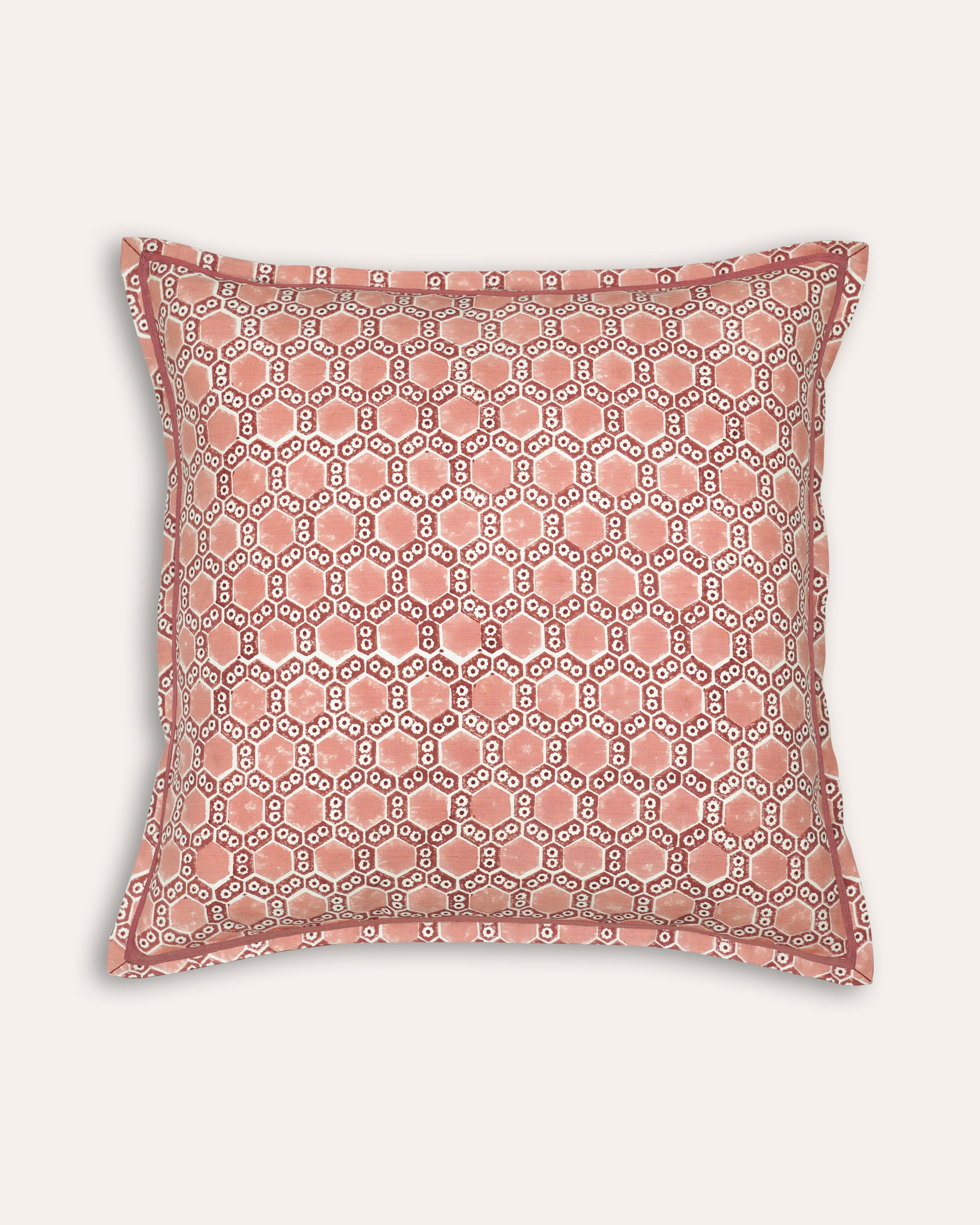 Geometric patterned pink square block printed cushion on a white background