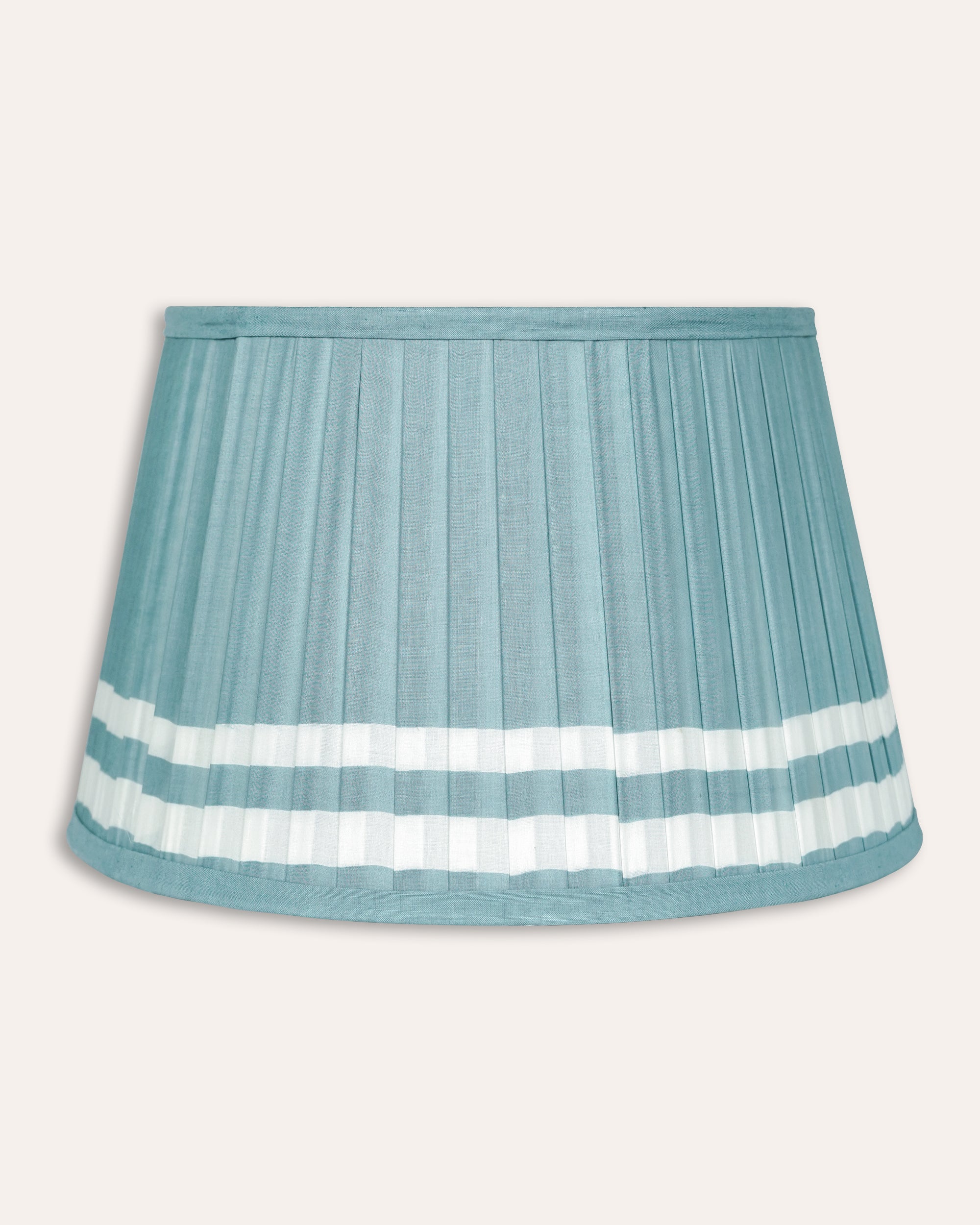 Light blue pleated lampshade with white stripes on a light grey background
