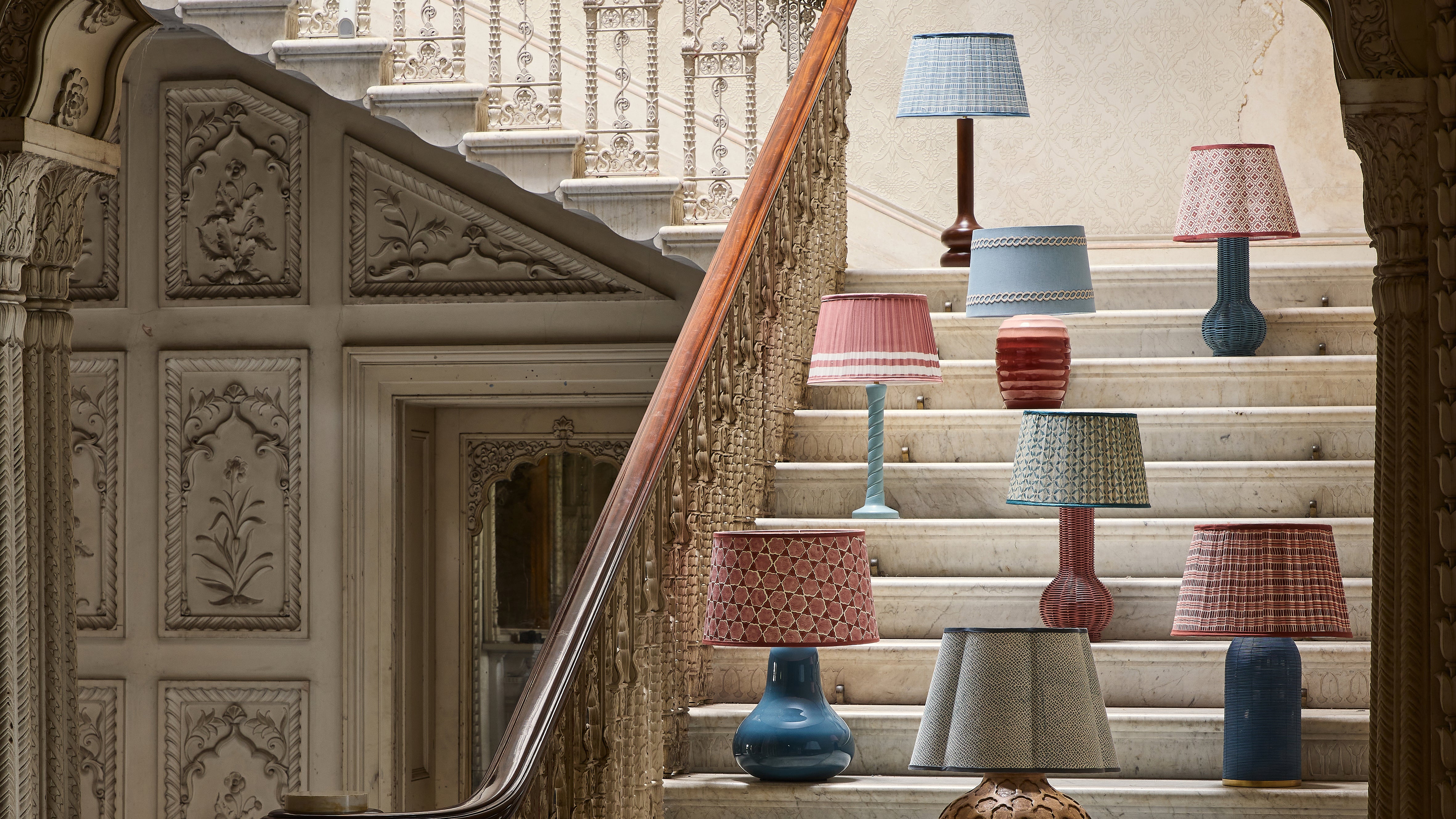 Staircase with decorative lamps in a room with ornate walls.