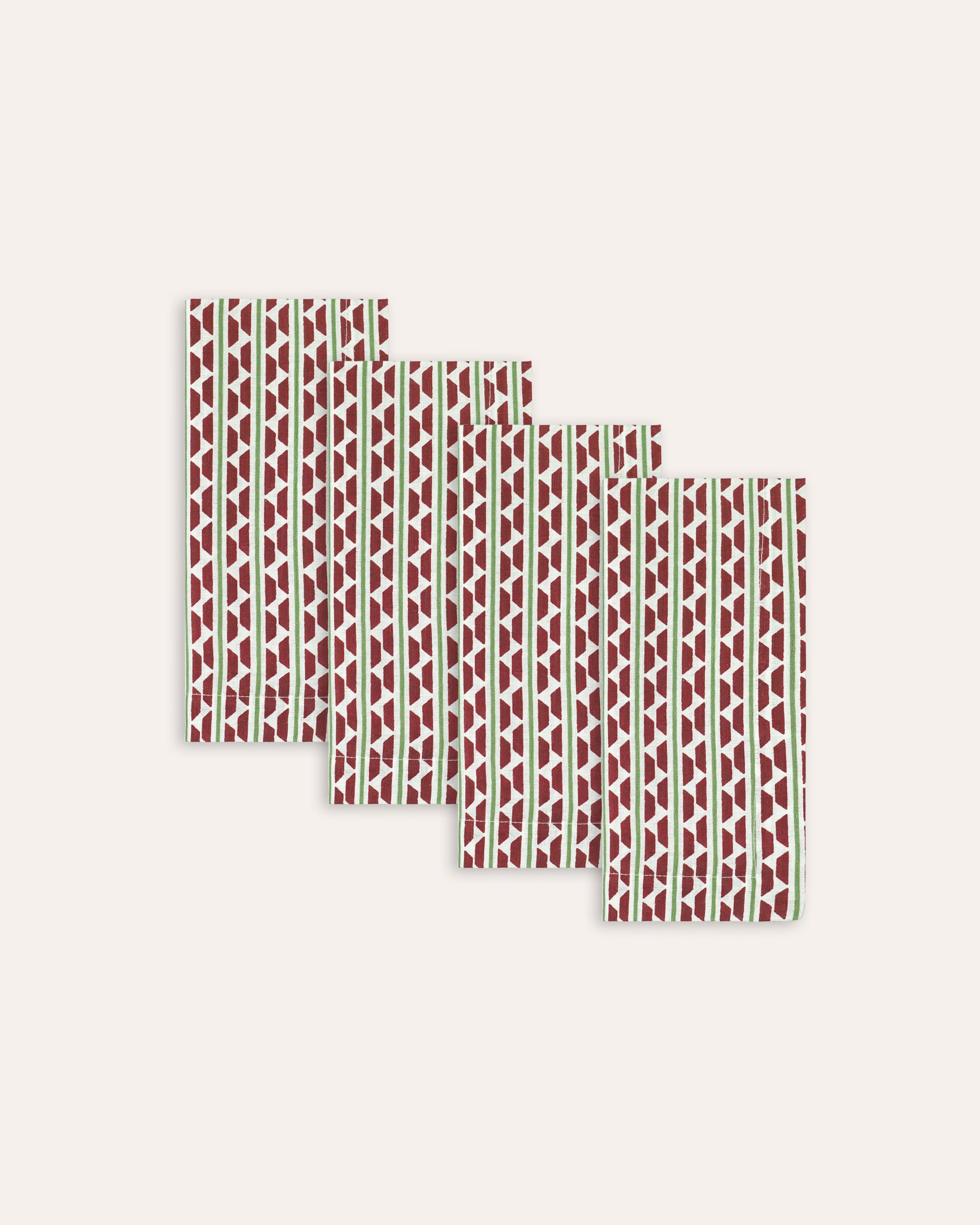 Set of four red and green patterned napkins on a white background