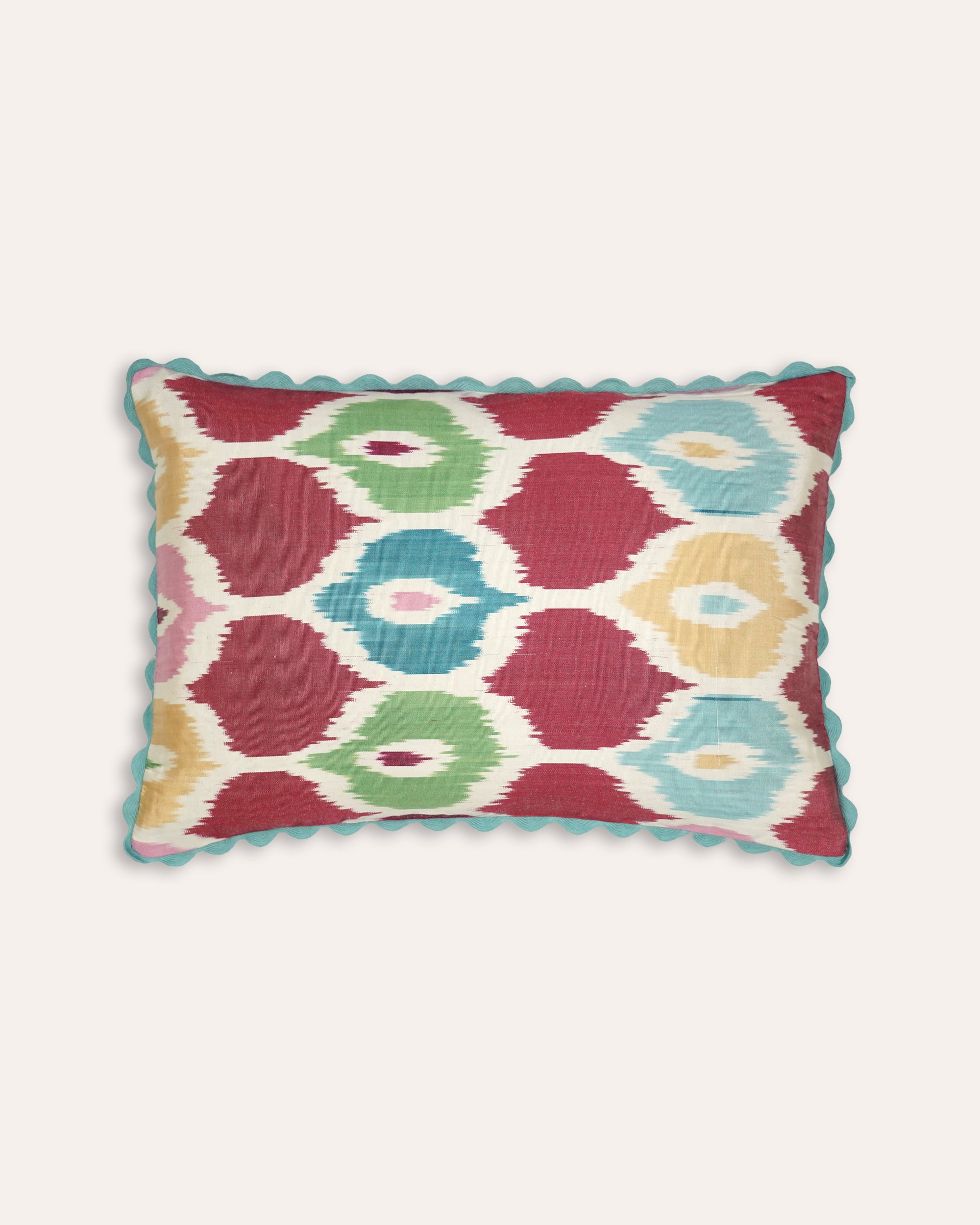 Decorative rectangular cushion with a colourful geometric pattern on a white background