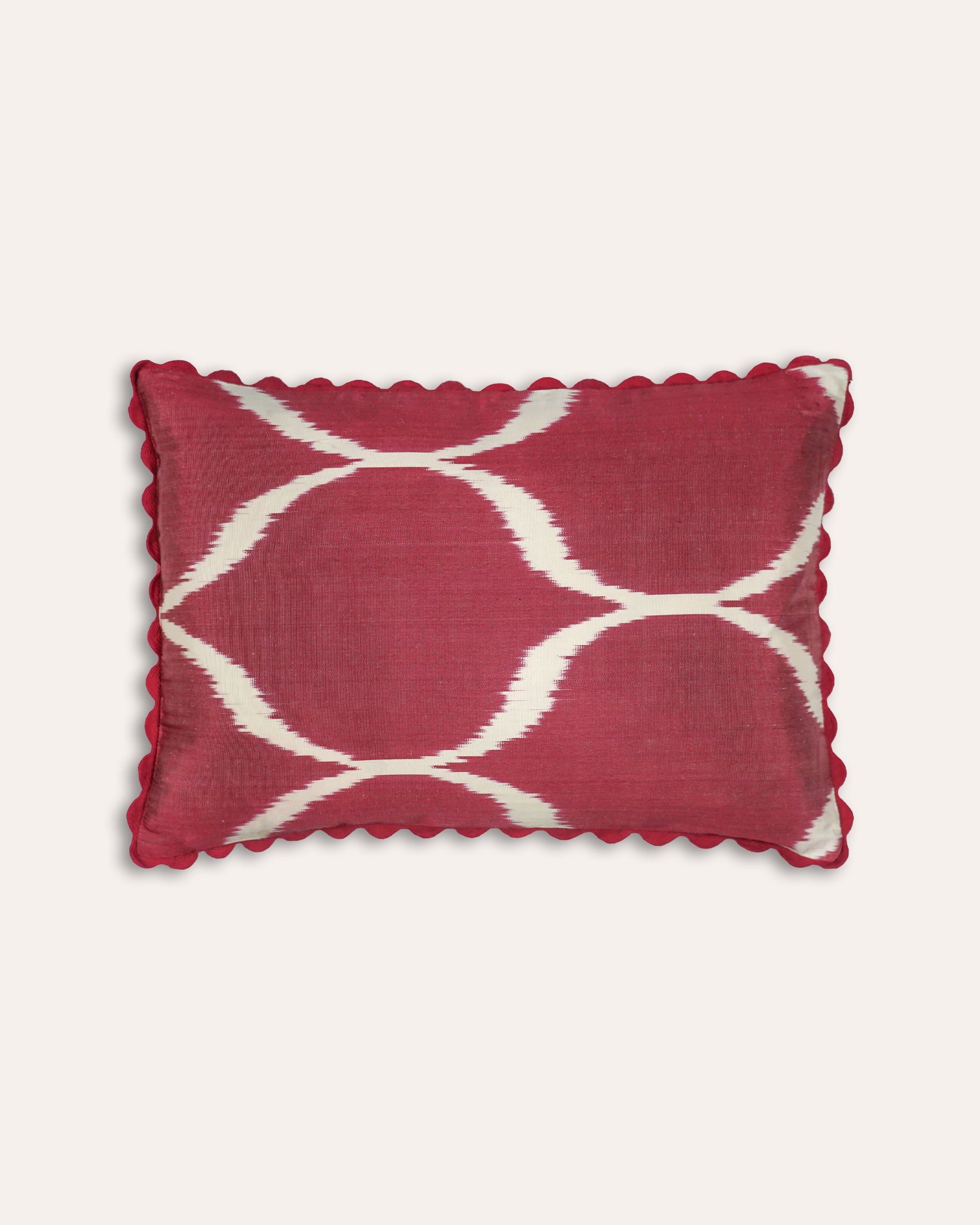 Red rectangular cushion with white geometric pattern on a white background