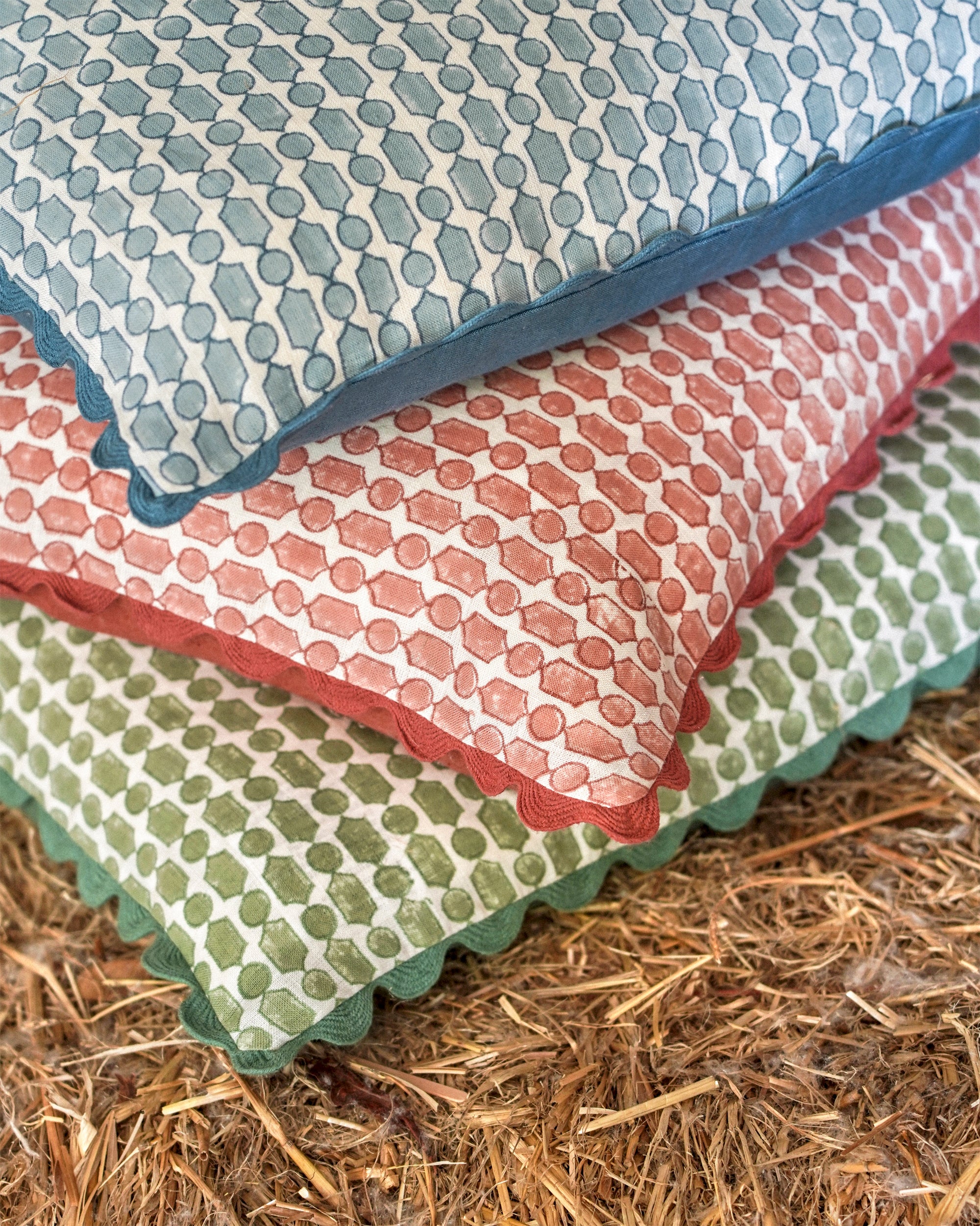 Stack of patterned fabric squares on a hay background