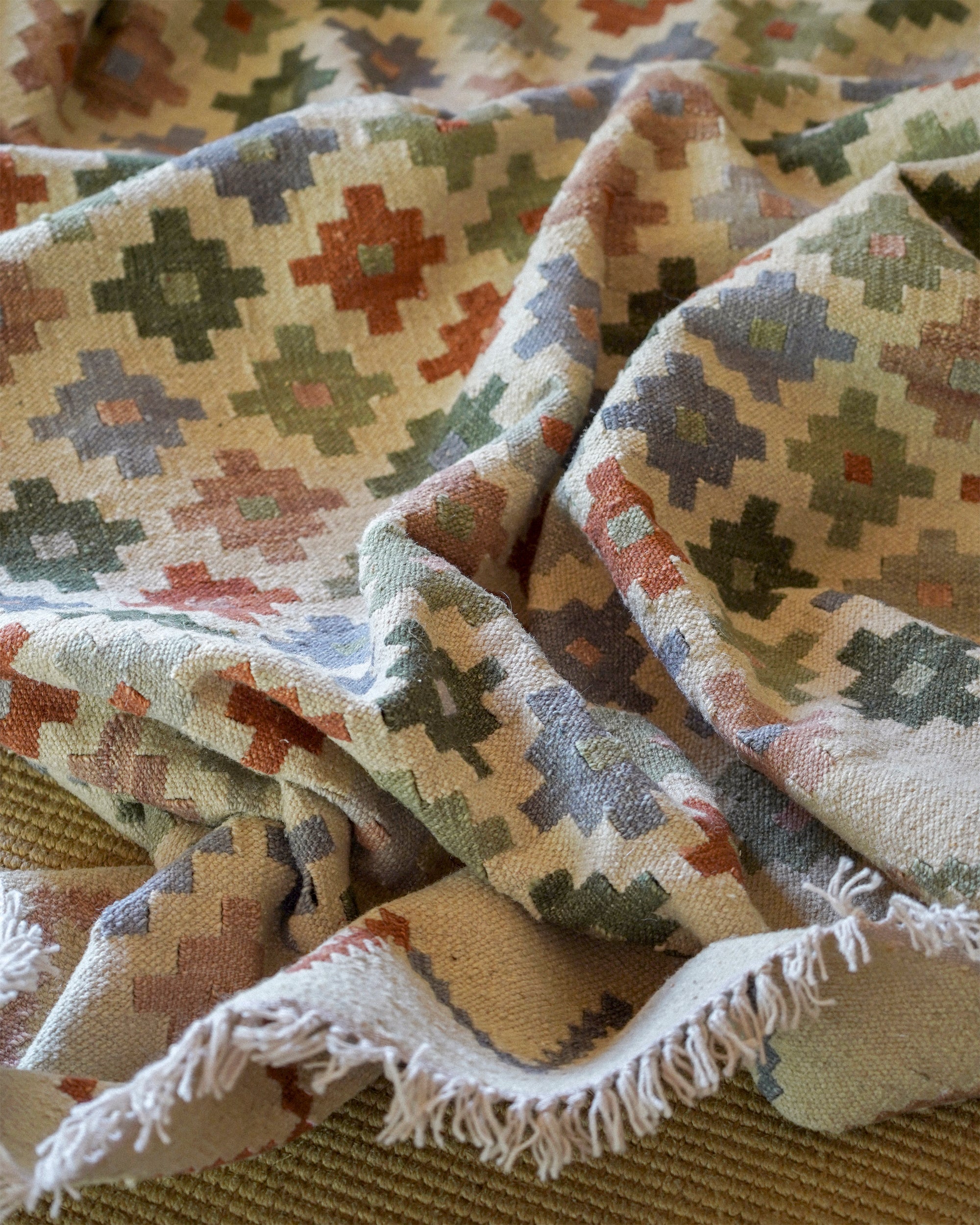 Close-up of a patterned rug with geometric designs in earthy tones.