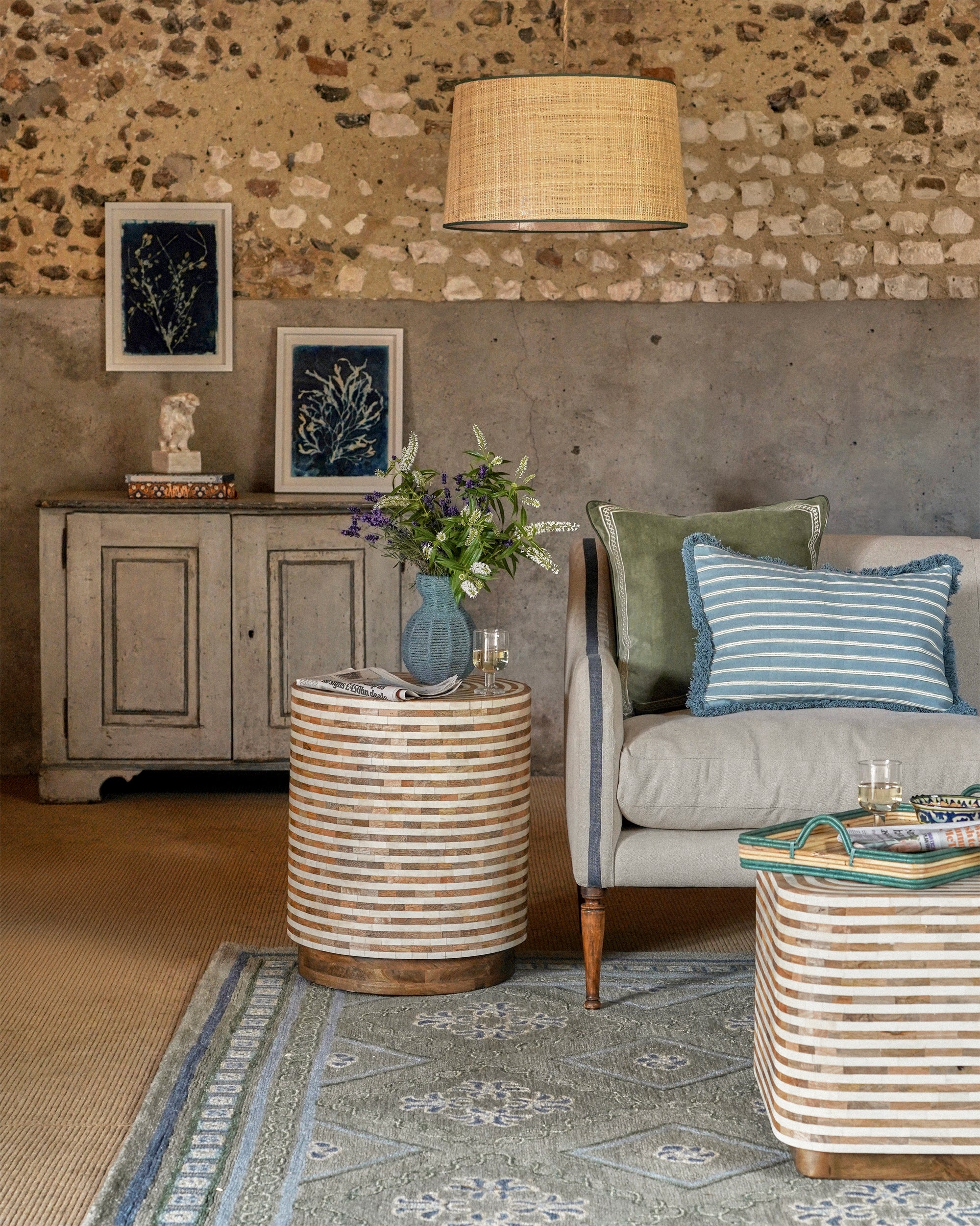 Living room with stone wall, gray sofa, and decorative elements.