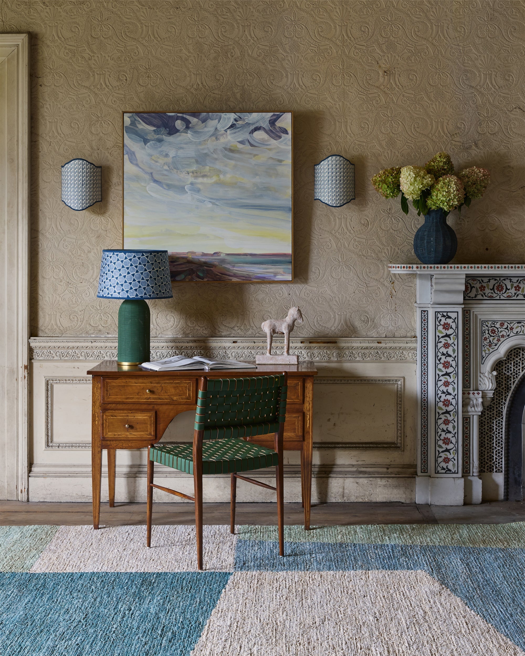 The gallery, artwork featured on wall behind a green and taupe dining set up