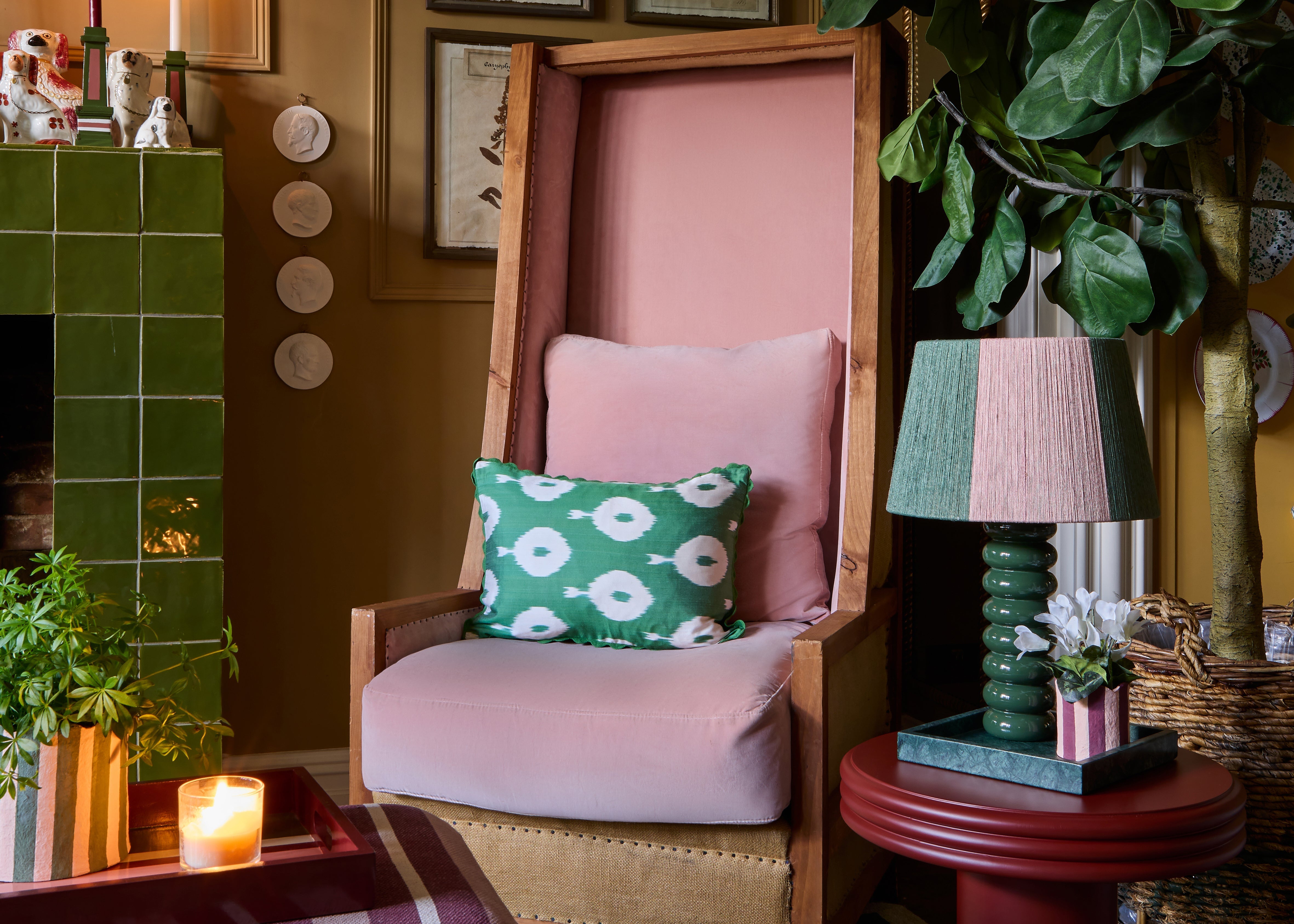 Pink and green themed living room, with pink chair, green ikat cushion, green lamp and pink and green striped lampshade