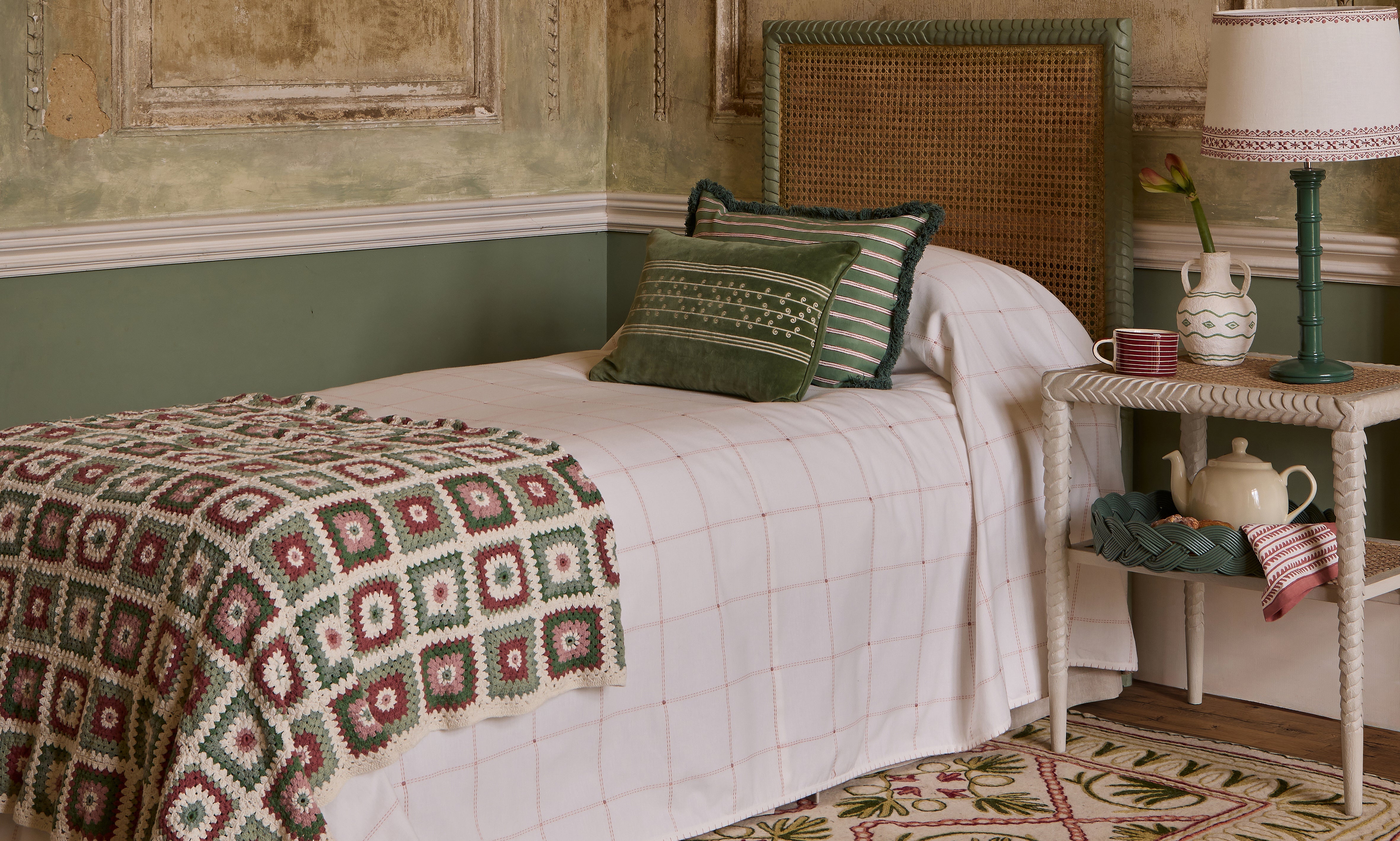 Image of a bedroom with a pink and green scheme including cushions by Birdie Fortescue