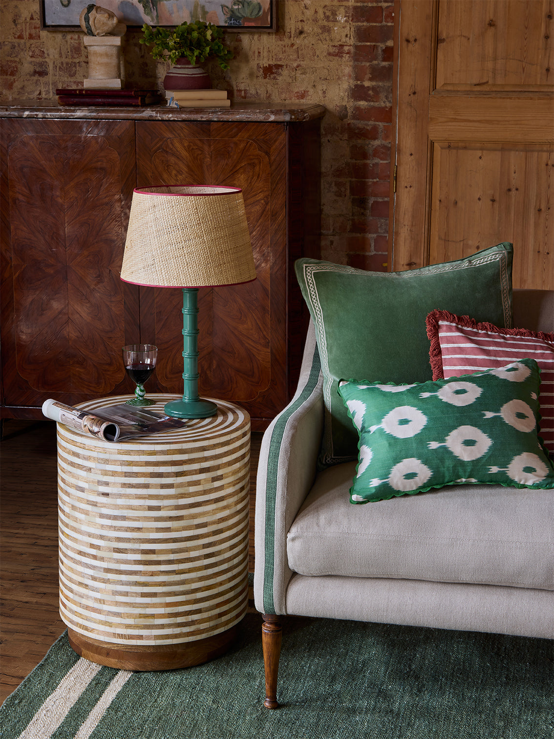 Green lamp with red lampshade on a side table