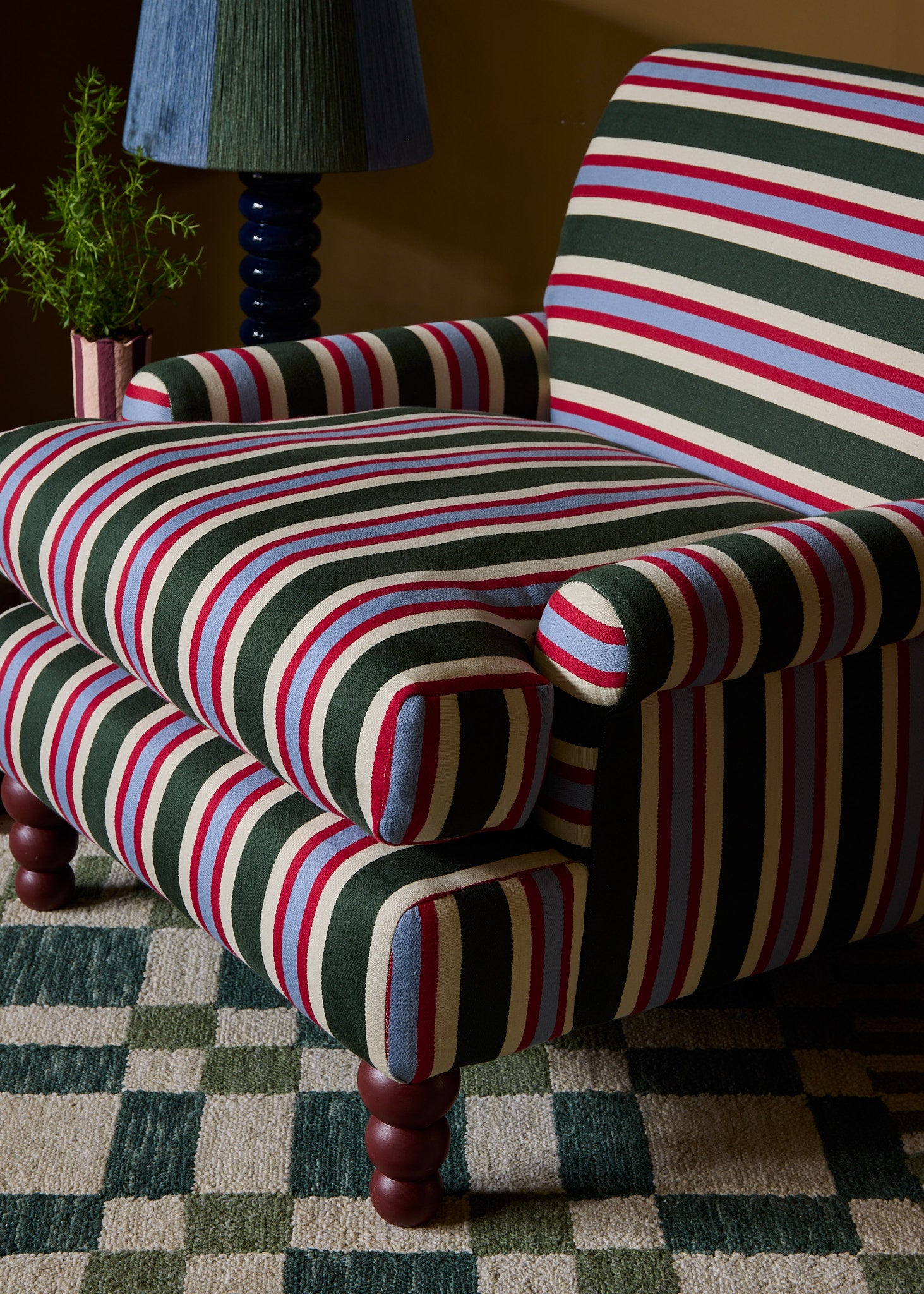 a close up shot of the striped heaven chair on the check mate rug in green