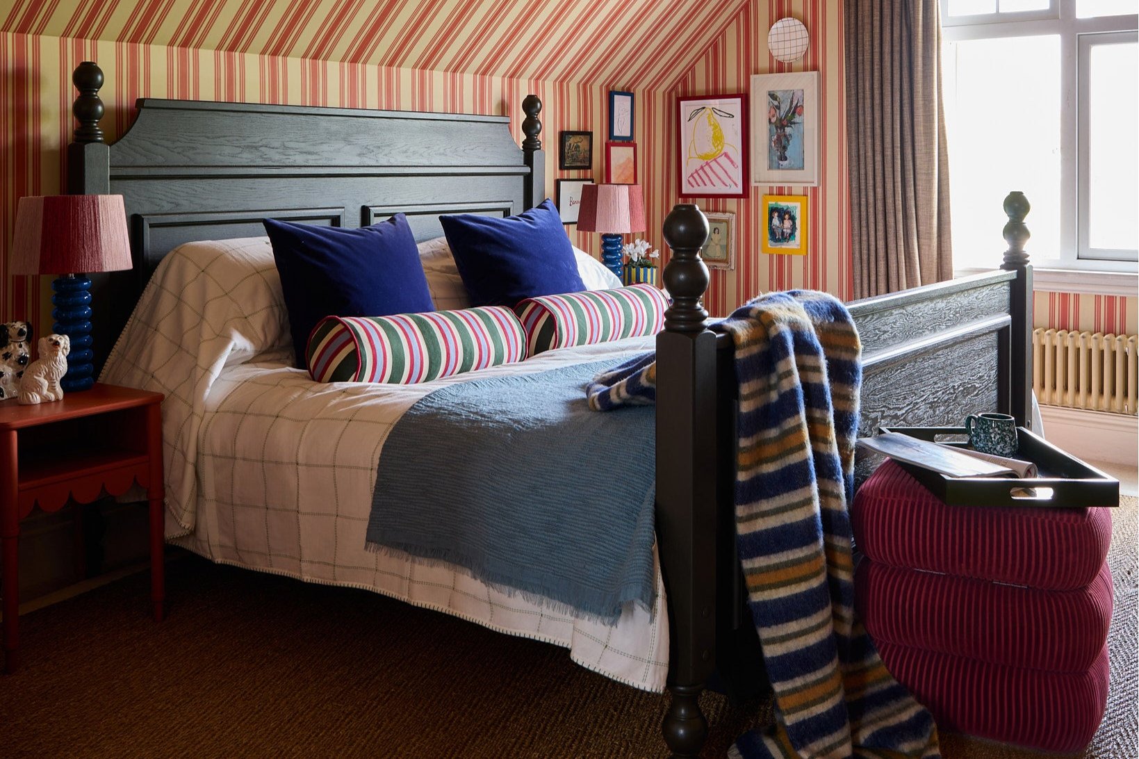 a landscape shot of Sarah's bedroom styled with the stripes galore bolster cushion, striped throw and classic stool in red