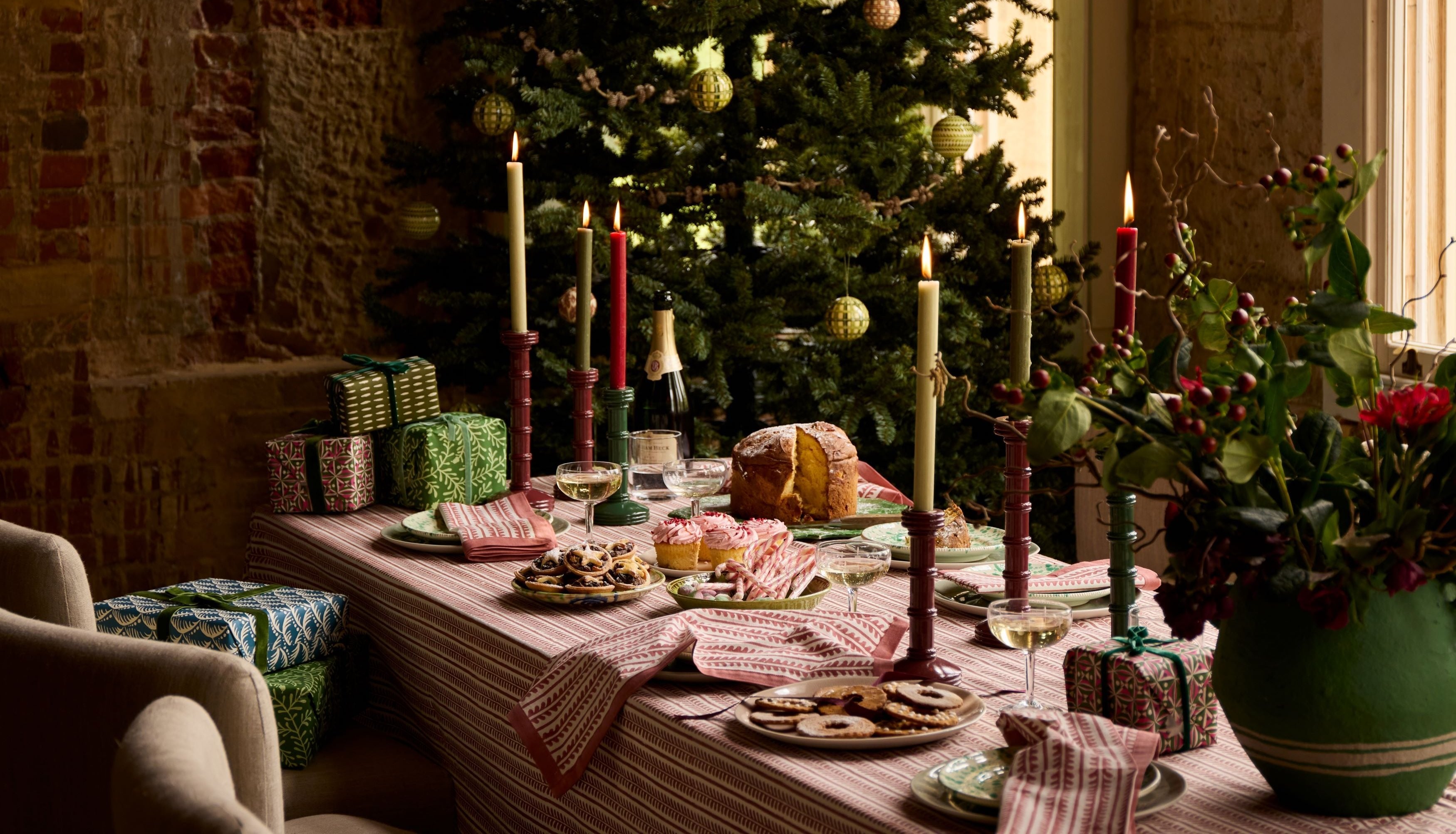 A christmas tablescape by Birdie Fortescue featuring bel table linen, twisted candlesticks and sweet festive treats