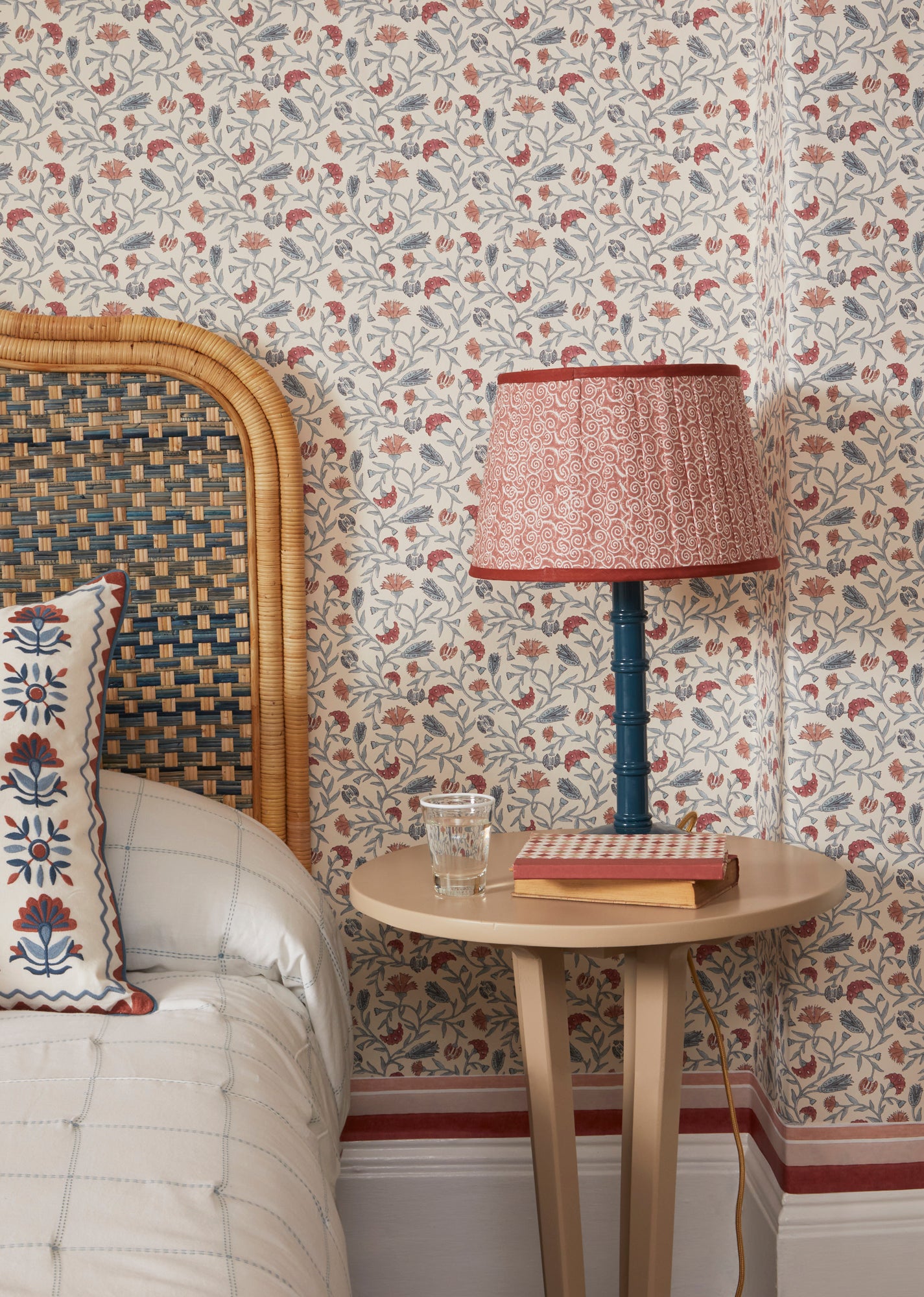 Close up bedroom side table lifestyle image showcasing the red and blue Andalusia wallpaper