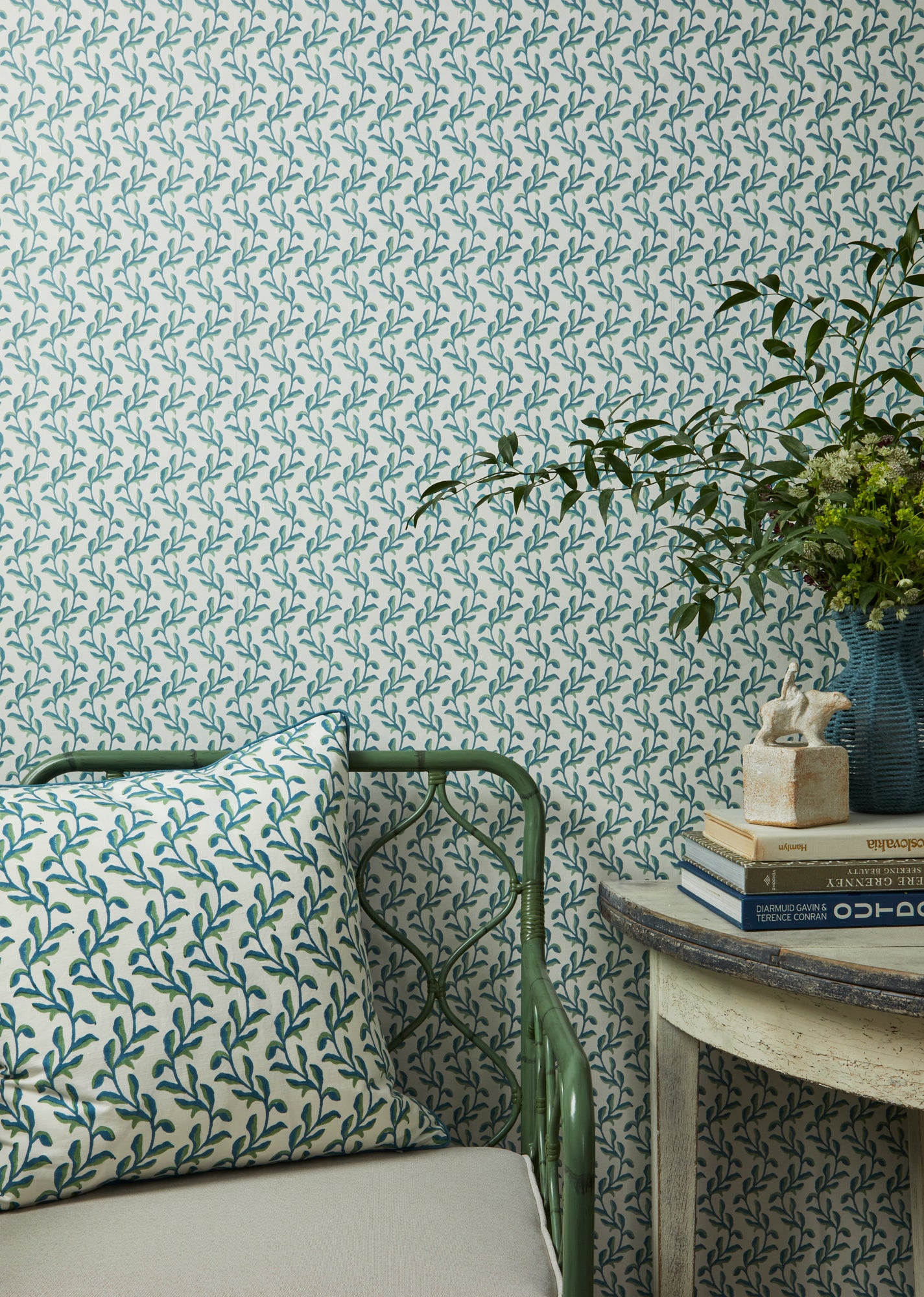 Close up detail lifestyle image featuring the Mariana floral wallpaper In blue and green