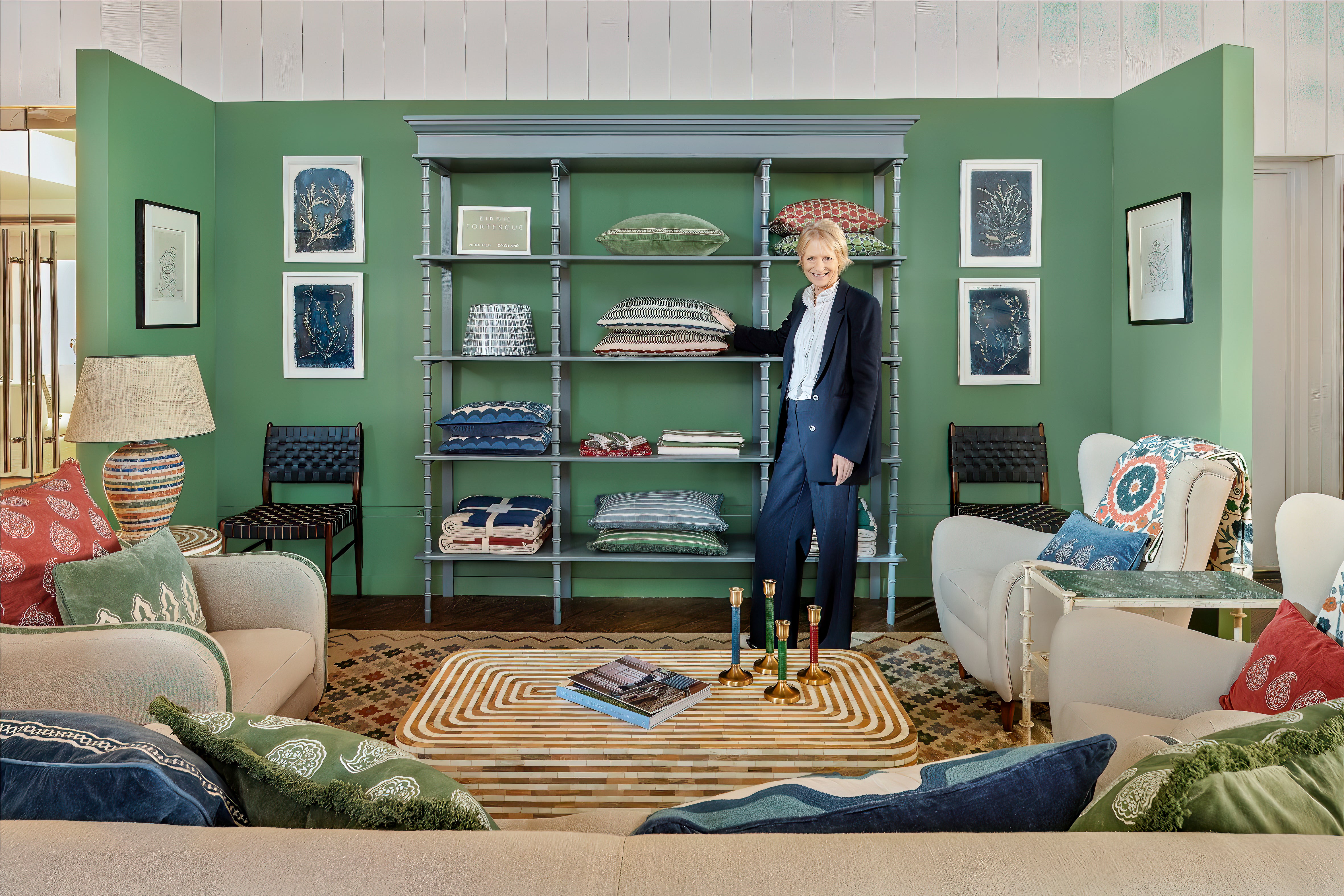 Birdie standing in a stylish living room with green walls, shelves, and furniture.