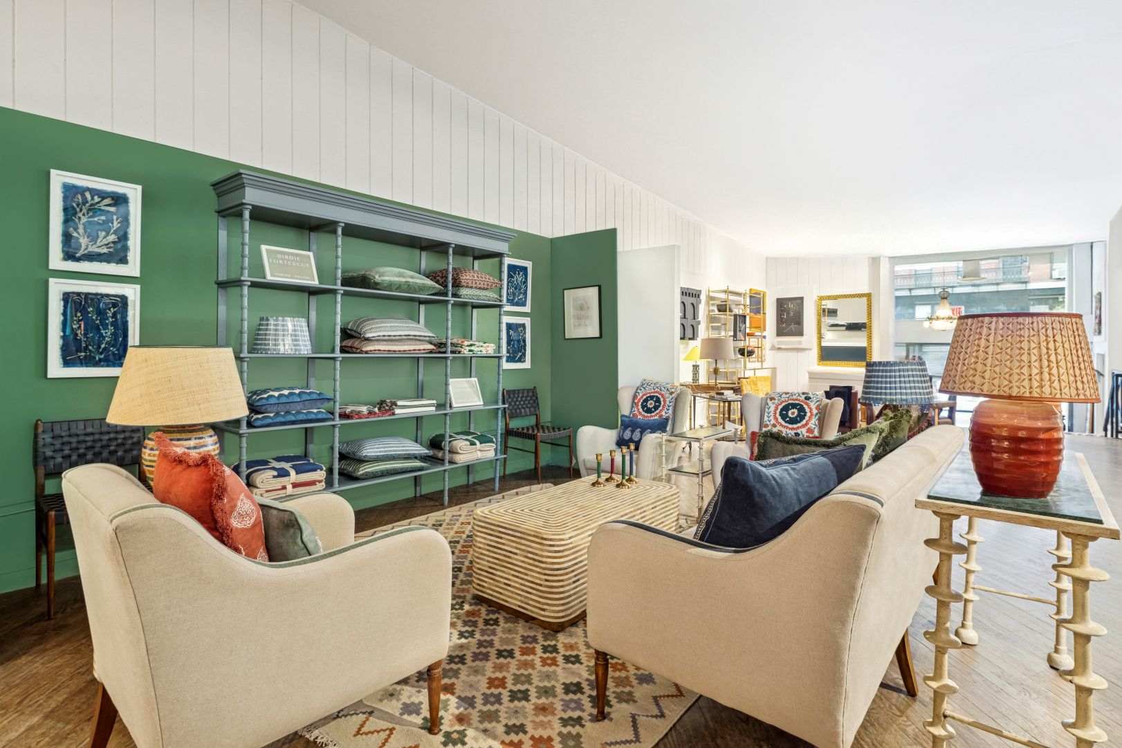 Sitting room with green walls, bookshelves, and decorative items.
