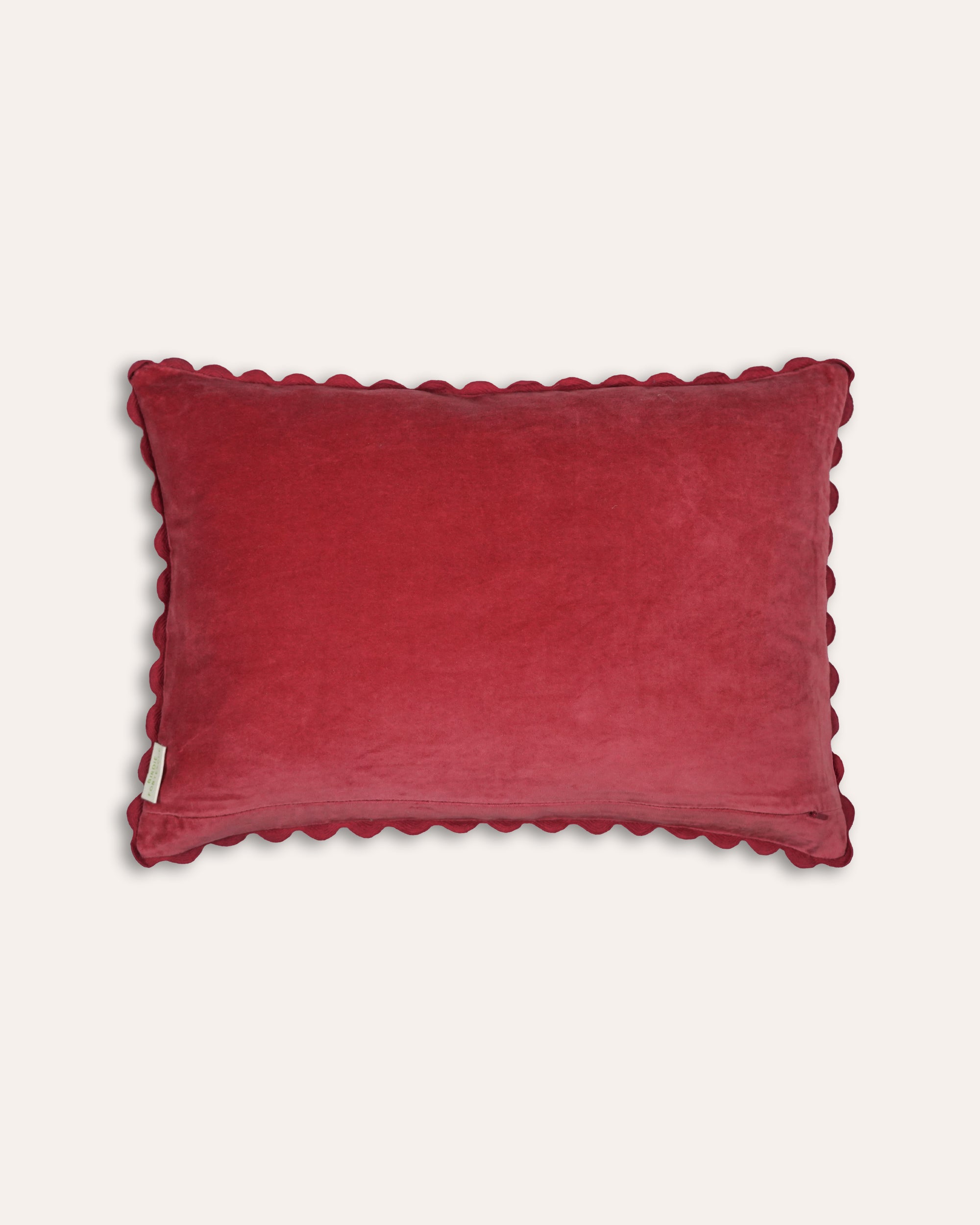 Red velvet cushion back with scalloped edge on a light grey background
