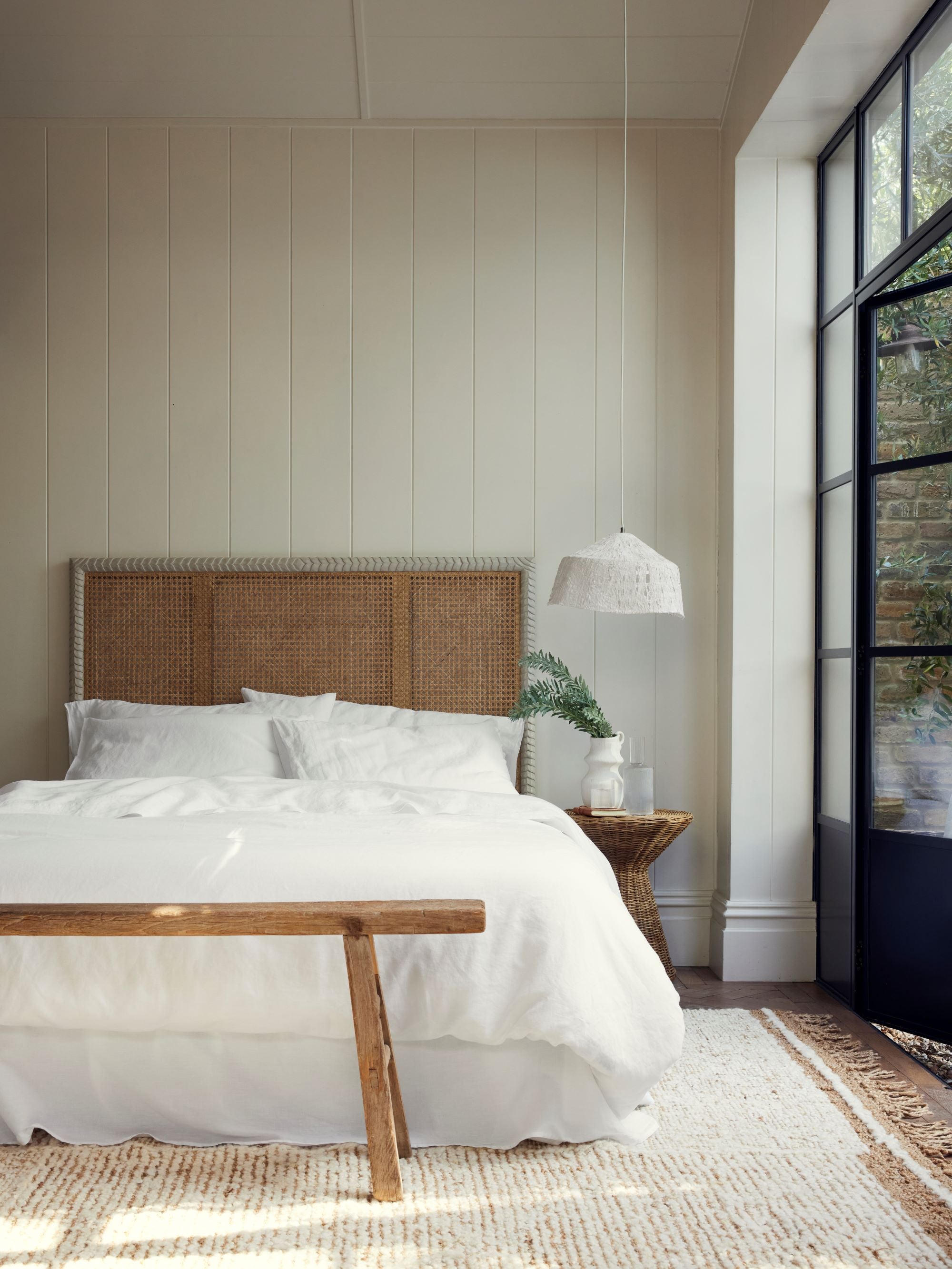 a wider range shot crisp white sheets by Piglet in bed styled with a pavilion headboard by Birdie Fortescue, also featuring the Buna Rug