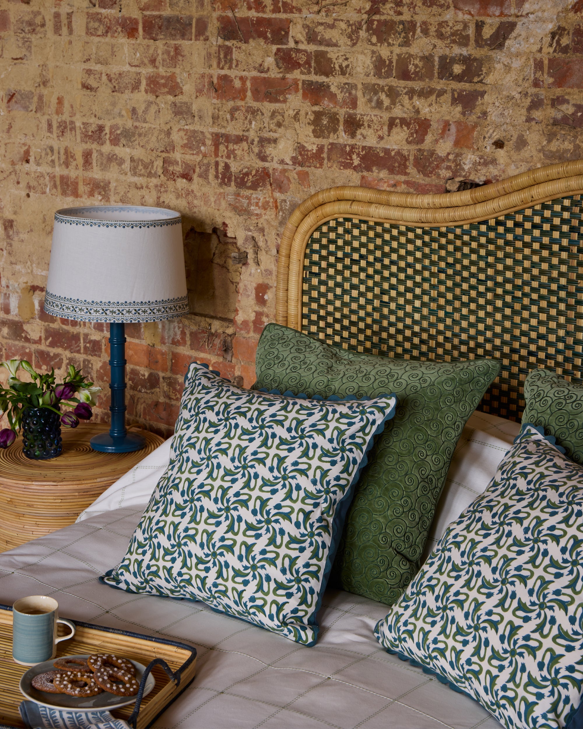 Remolino Embroidered Velvet Cushion - Green, in a green and blue bedroom scheme