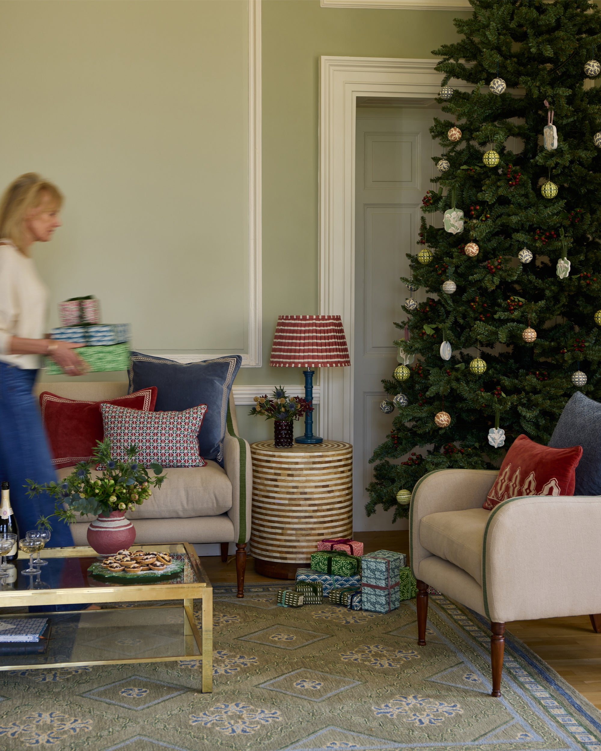 Festive sitting room featuring green Varuna rug, green uplostered sofa and armchair and Havana Inlay side table