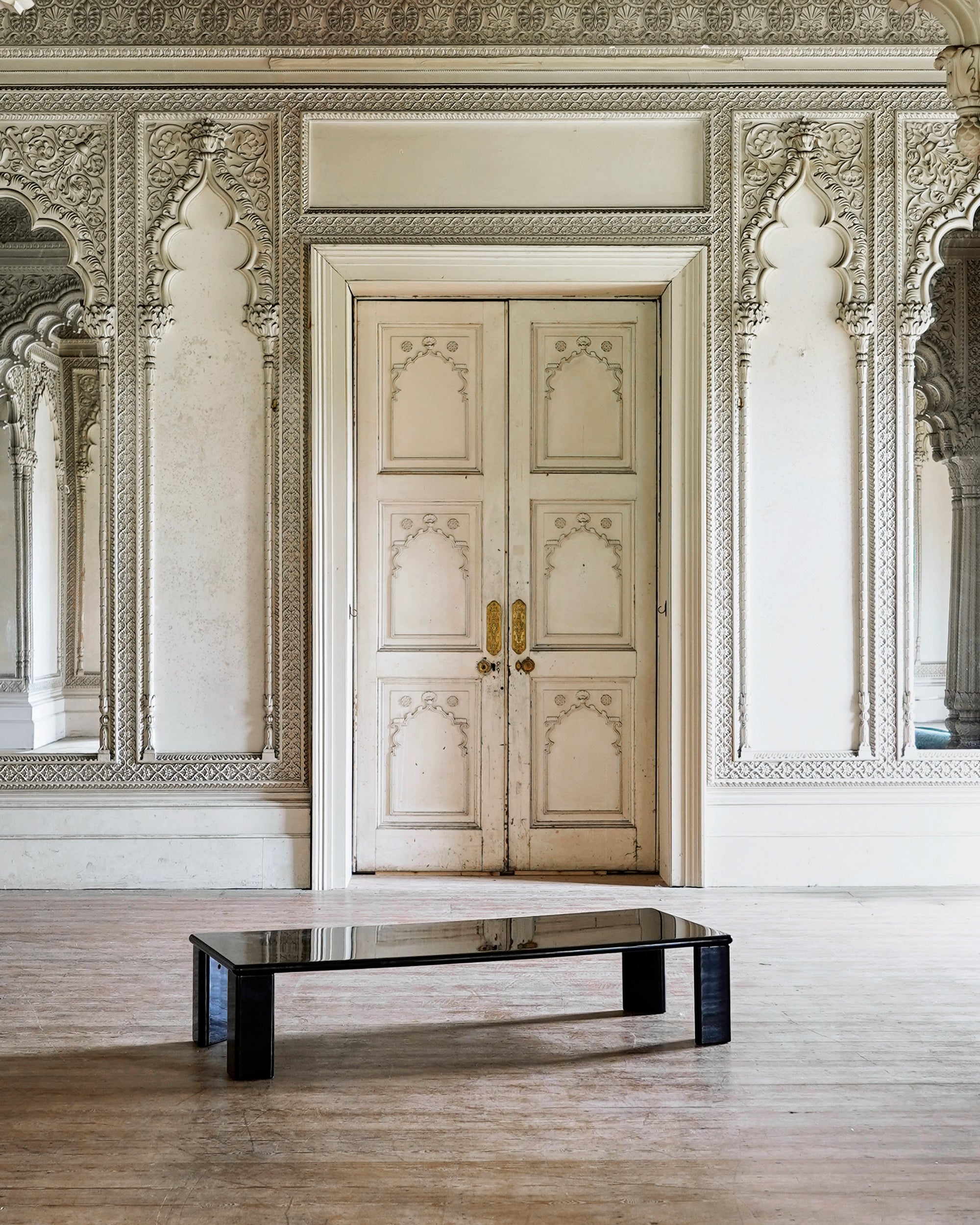 Decorative interior with ornate walls and a closed door.