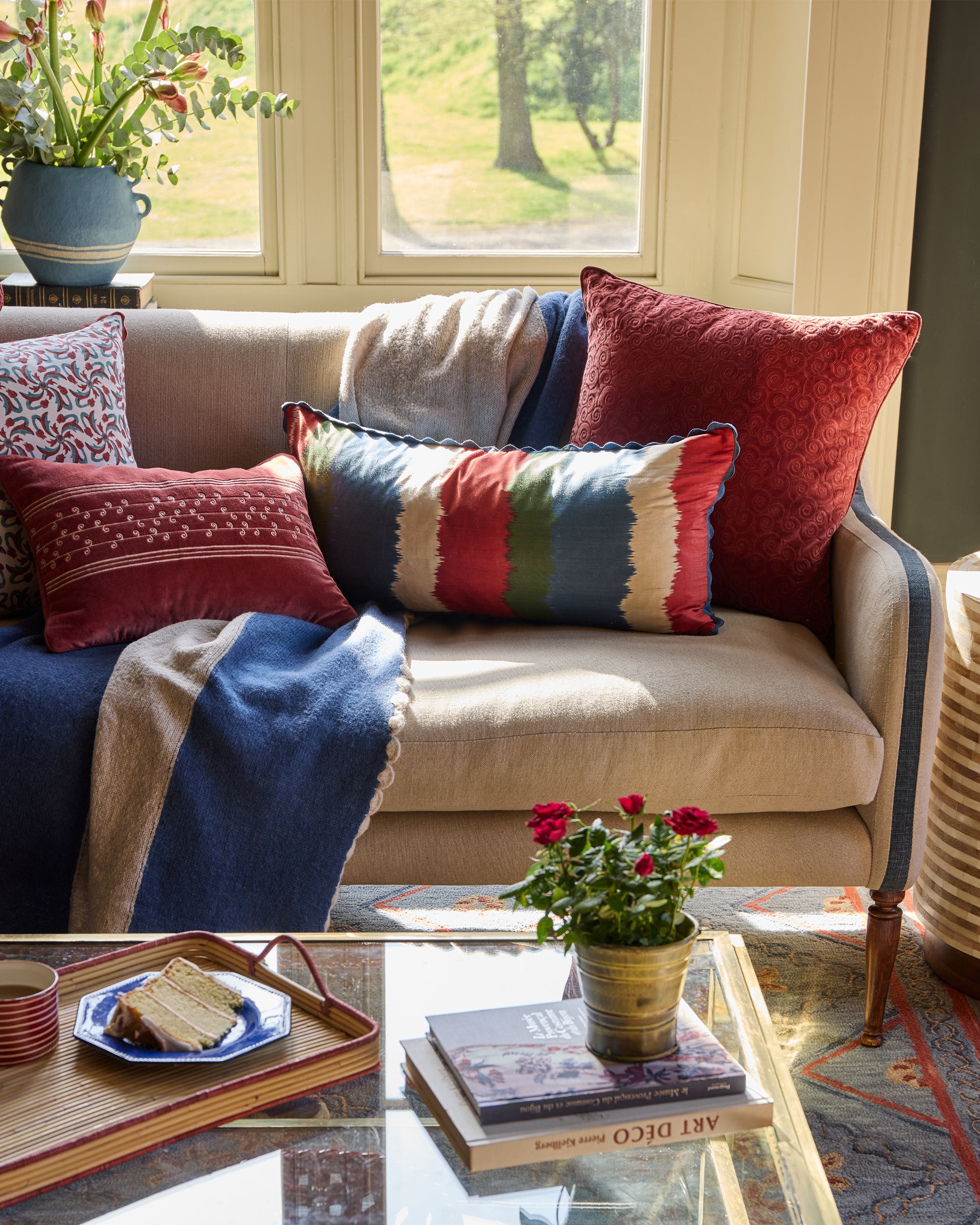 Remolino Embroidered Velvet Cushion - Red, on a bright sofa arrangement