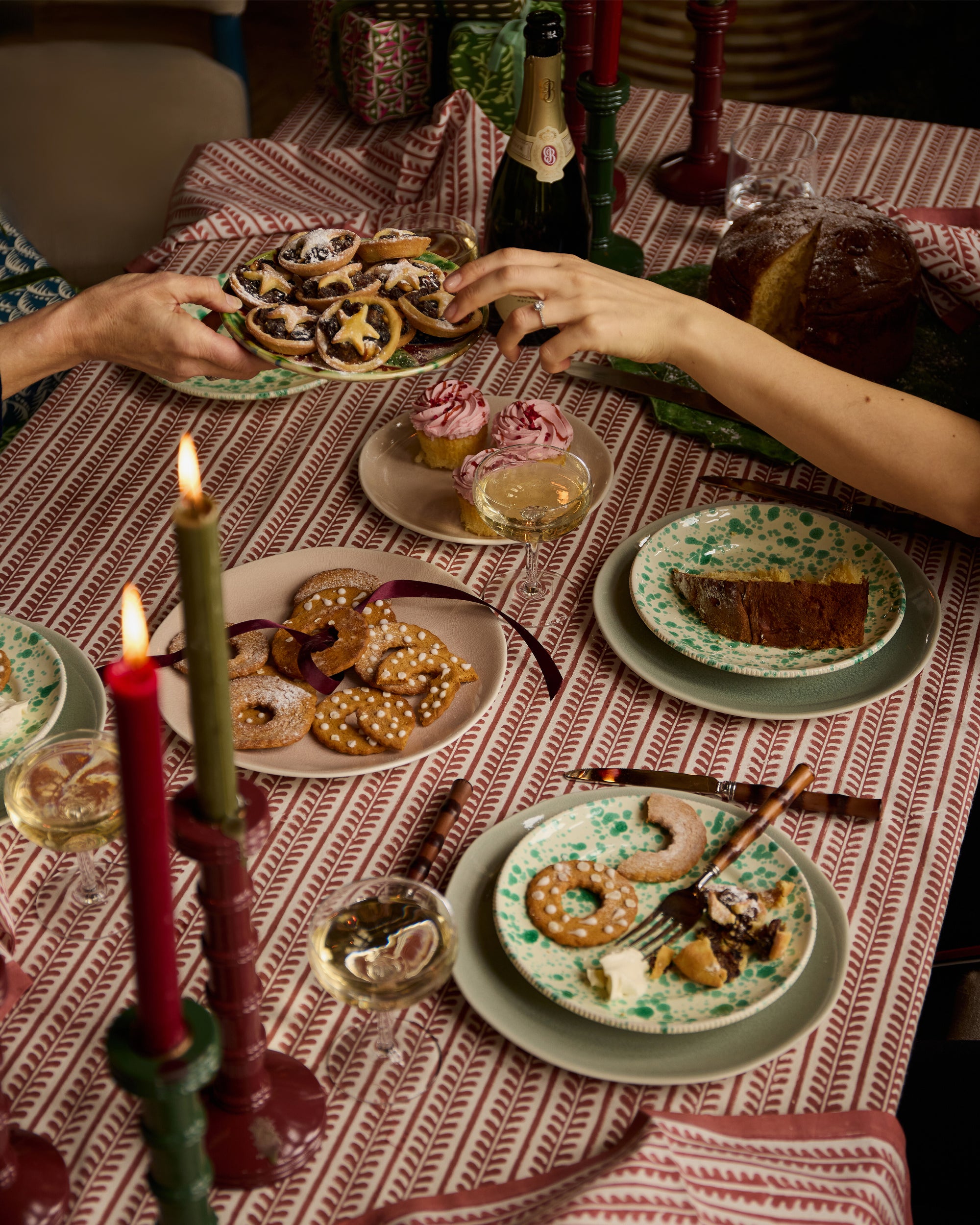 Festive dining featuring red bel tablecloth, red bel napkins and green and red wooden column candlesticks