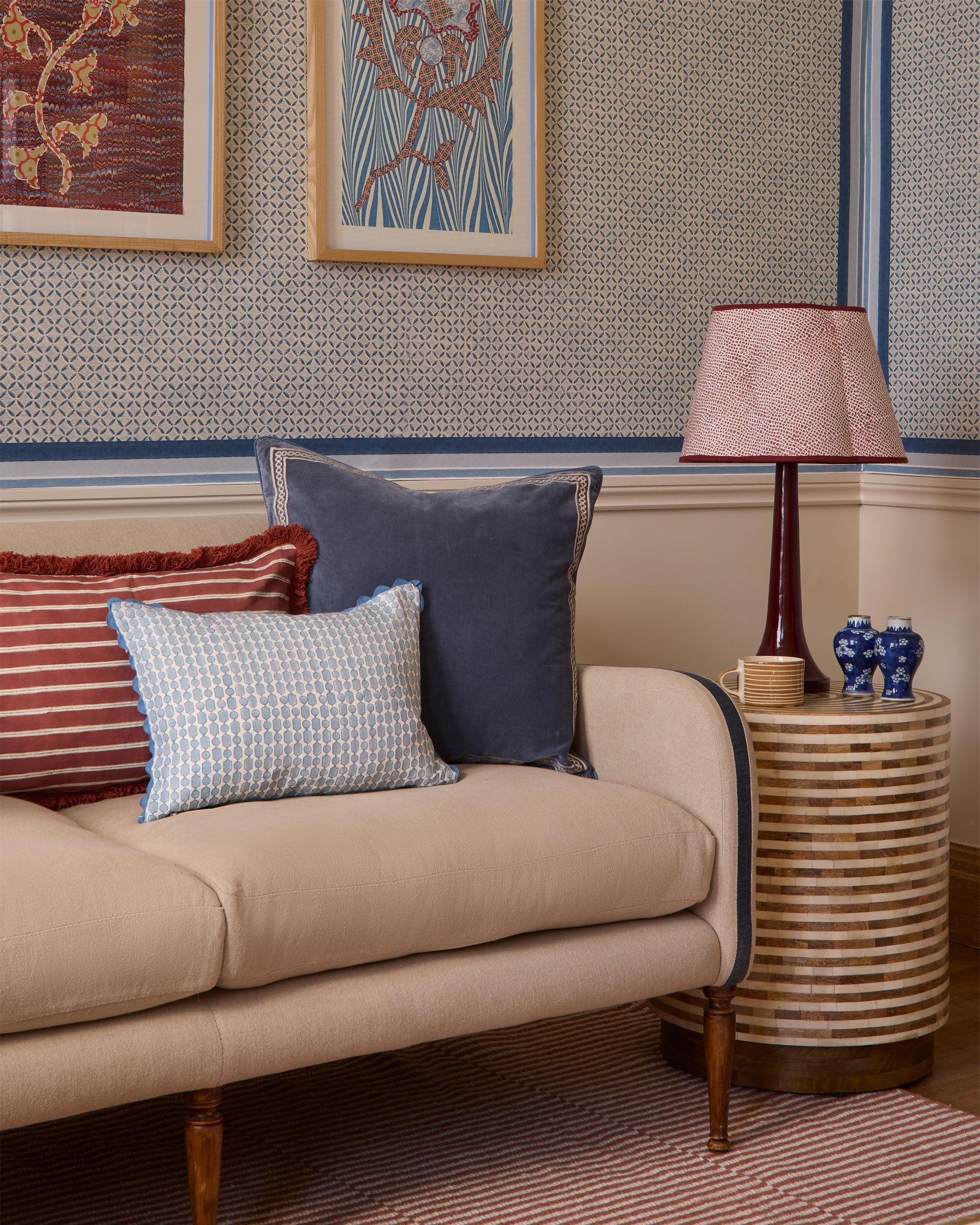 Living room with beige sofa, decorative pillows, and a side table with a lamp.