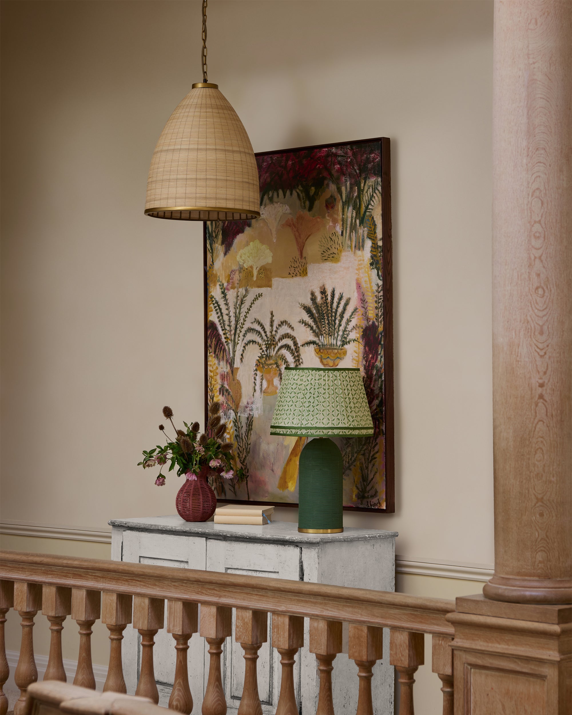 Decorative interior with a lamp, vase, and artwork on a console table.