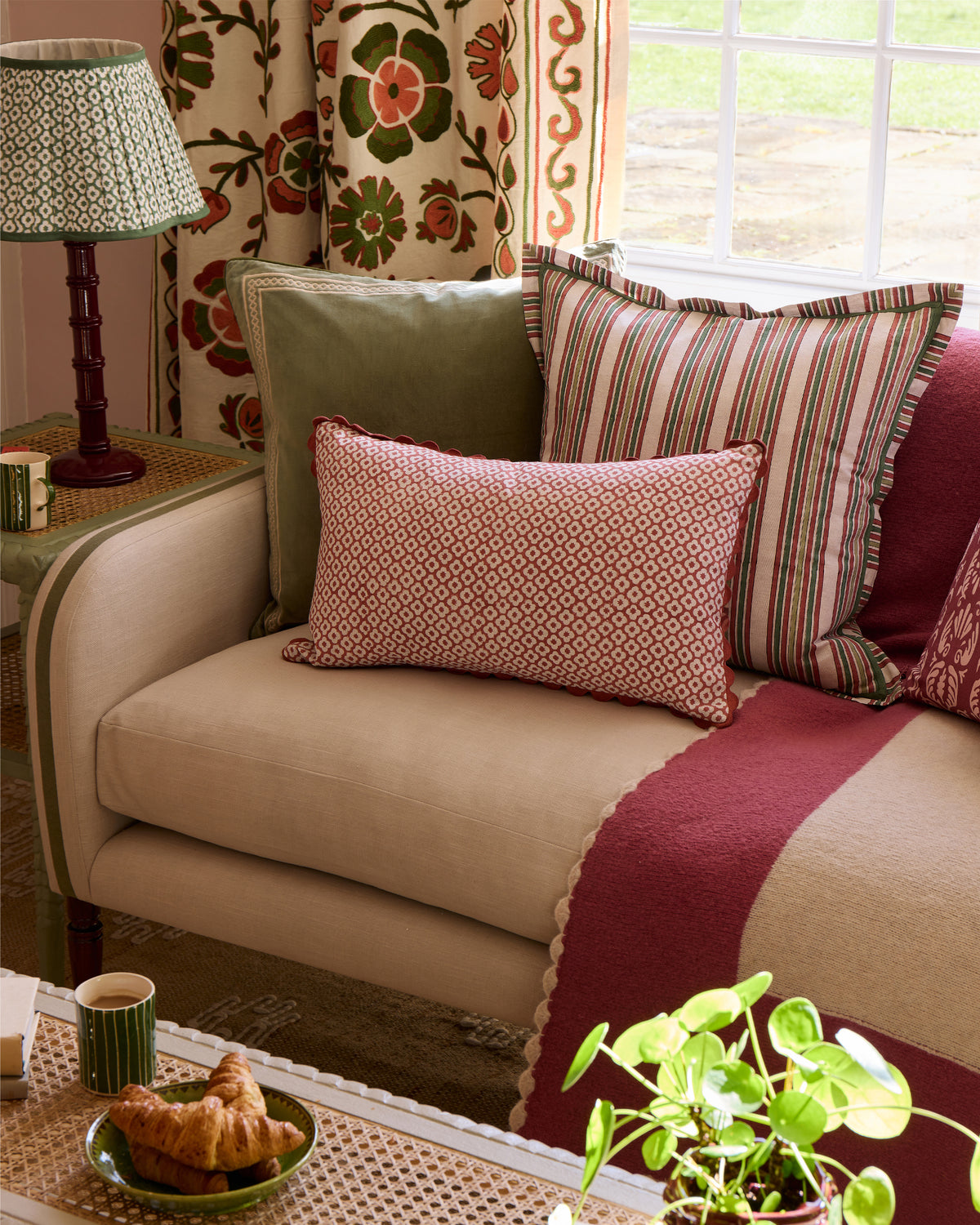 Beige sofa with patterned cushions and a lamp in a cozy sitting room.