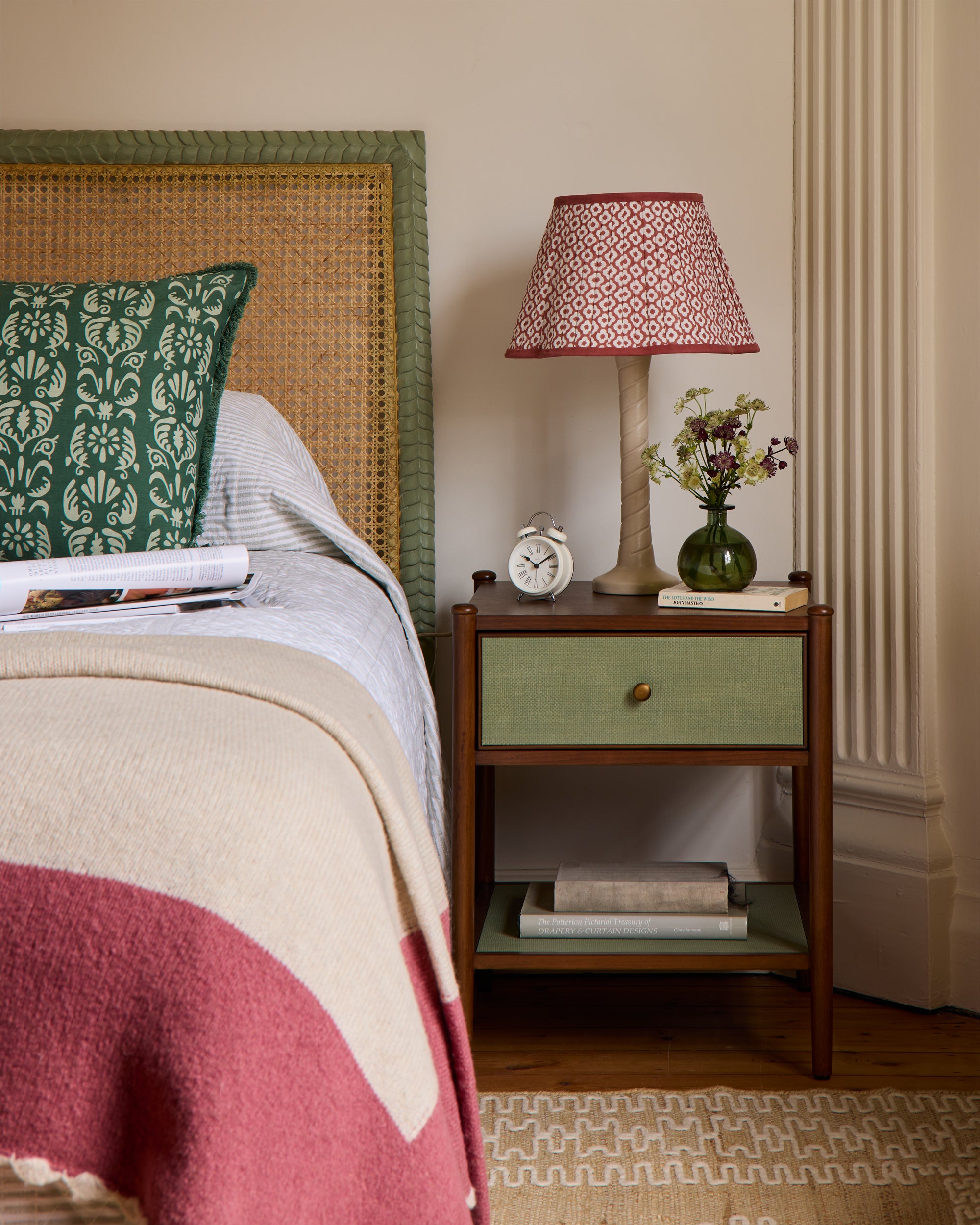 Bedroom with a bed, nightstand, lamp, and decorative items.